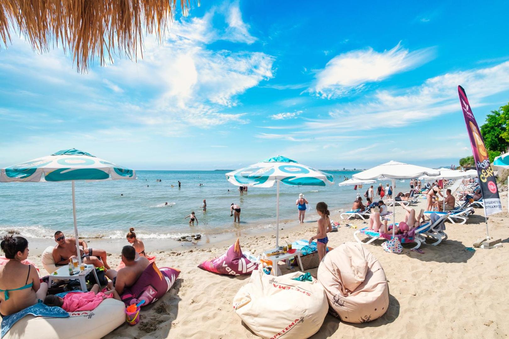 Premier Fort Beach Hotel pludmales atpūtas zona ar sēžammaisiem un saulessargiem smiltīs pie pašas jūras malas