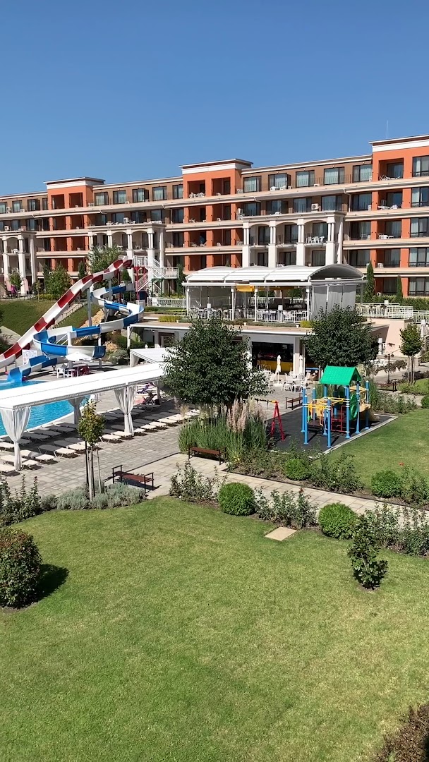 Premier Fort Beach Hotel bērnu rotaļu laukums un ūdens slidkalniņš pie baseina, fonā viesnīcas korpuss ar balkoniem