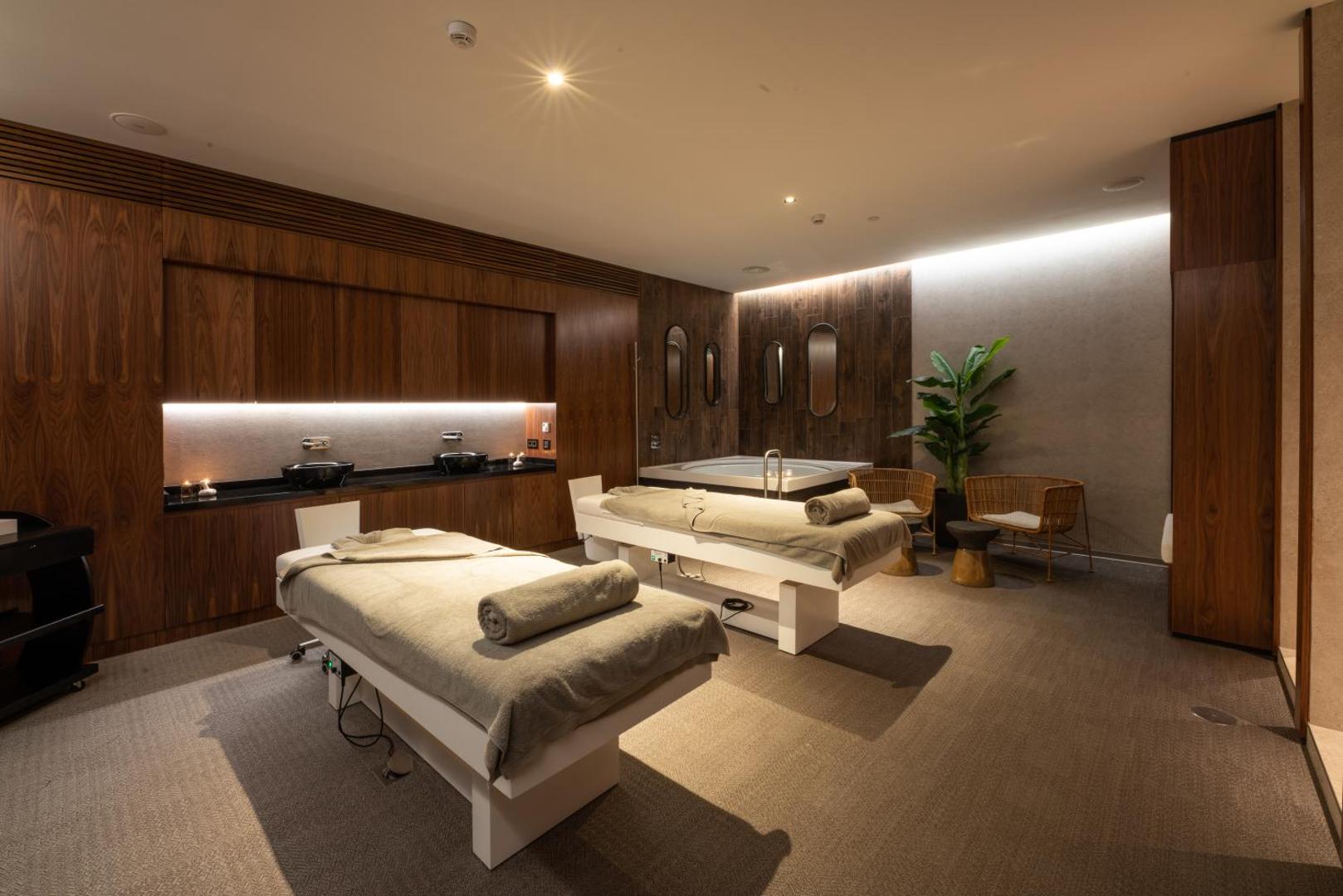 Sir Anthony Hotel spa procedūru numurs ar diviem masāžas galdiem, džakuzi vannu un elegantu koka interjeru