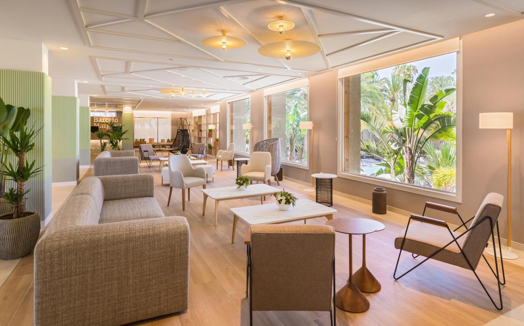 Barcelo Margaritas lobby atpūtas zona ar ērtiem dīvāniem, atpūtas krēsliem un lieliem logiem uz dārzu Grankanārijā