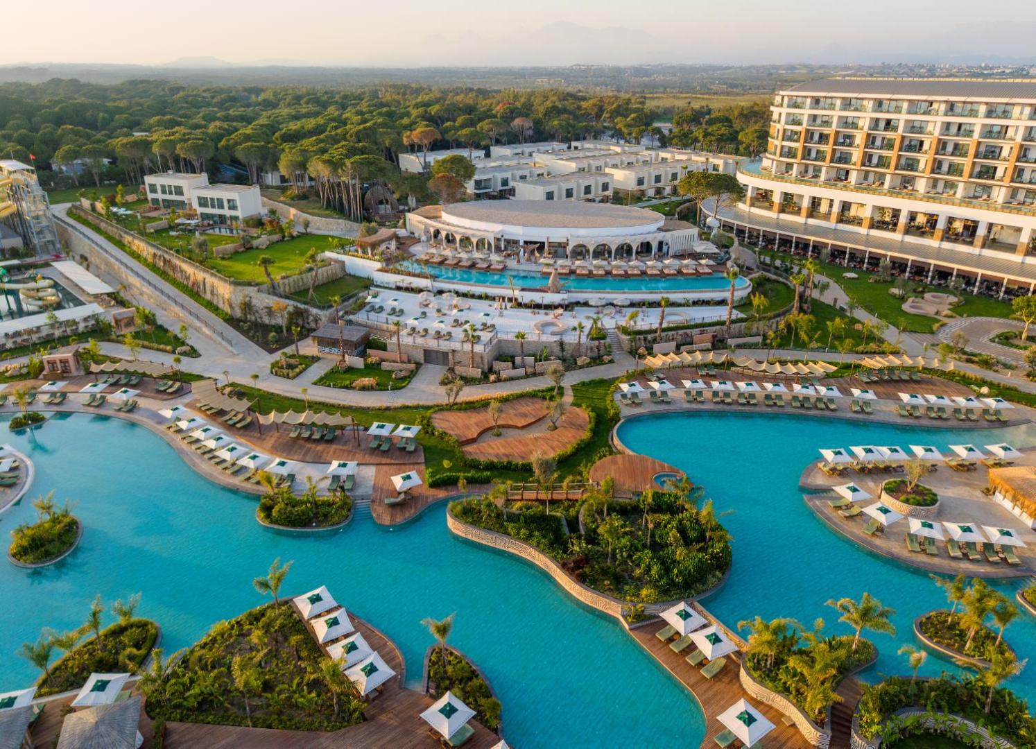 Ethno Belek viesnīcas teritorijas skats no augšas ar baseiniem, priežu mežu un galveno ēku Belekā — plaša atpūtas zona