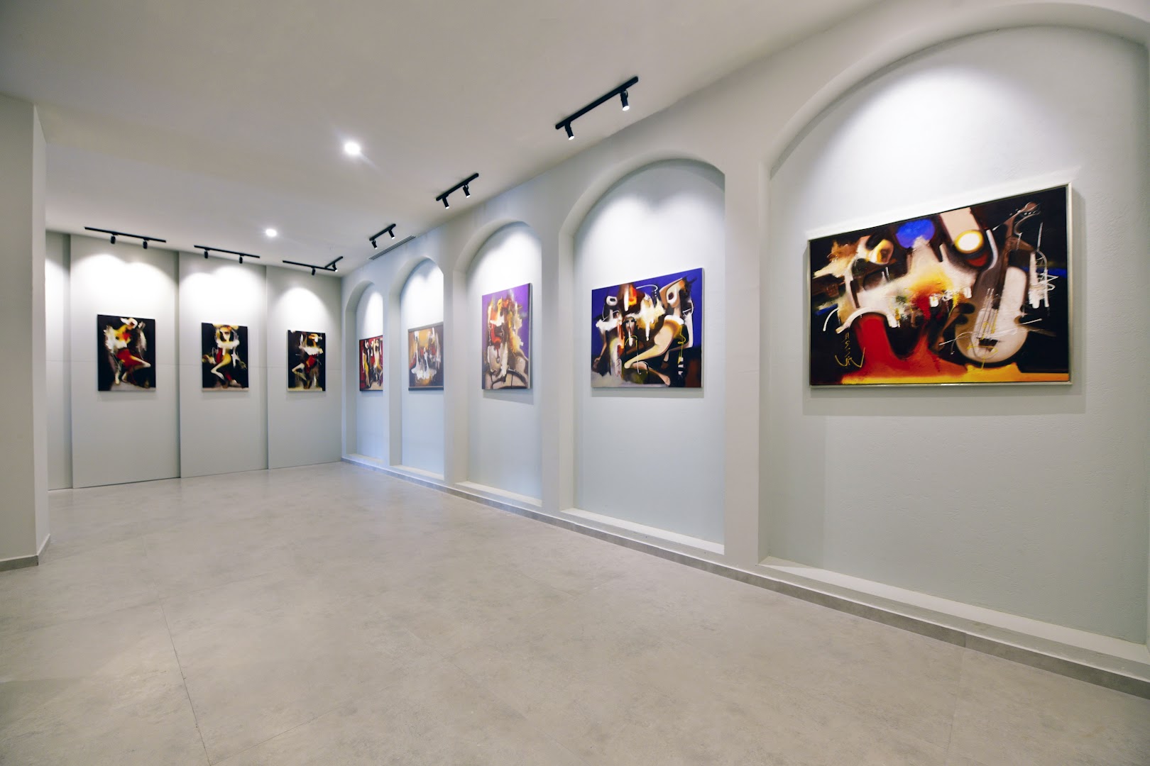 Ethno Belek viesnīcas mākslas galerija ar modernām gleznām pie baltām sienām un profesionālu apgaismojumu