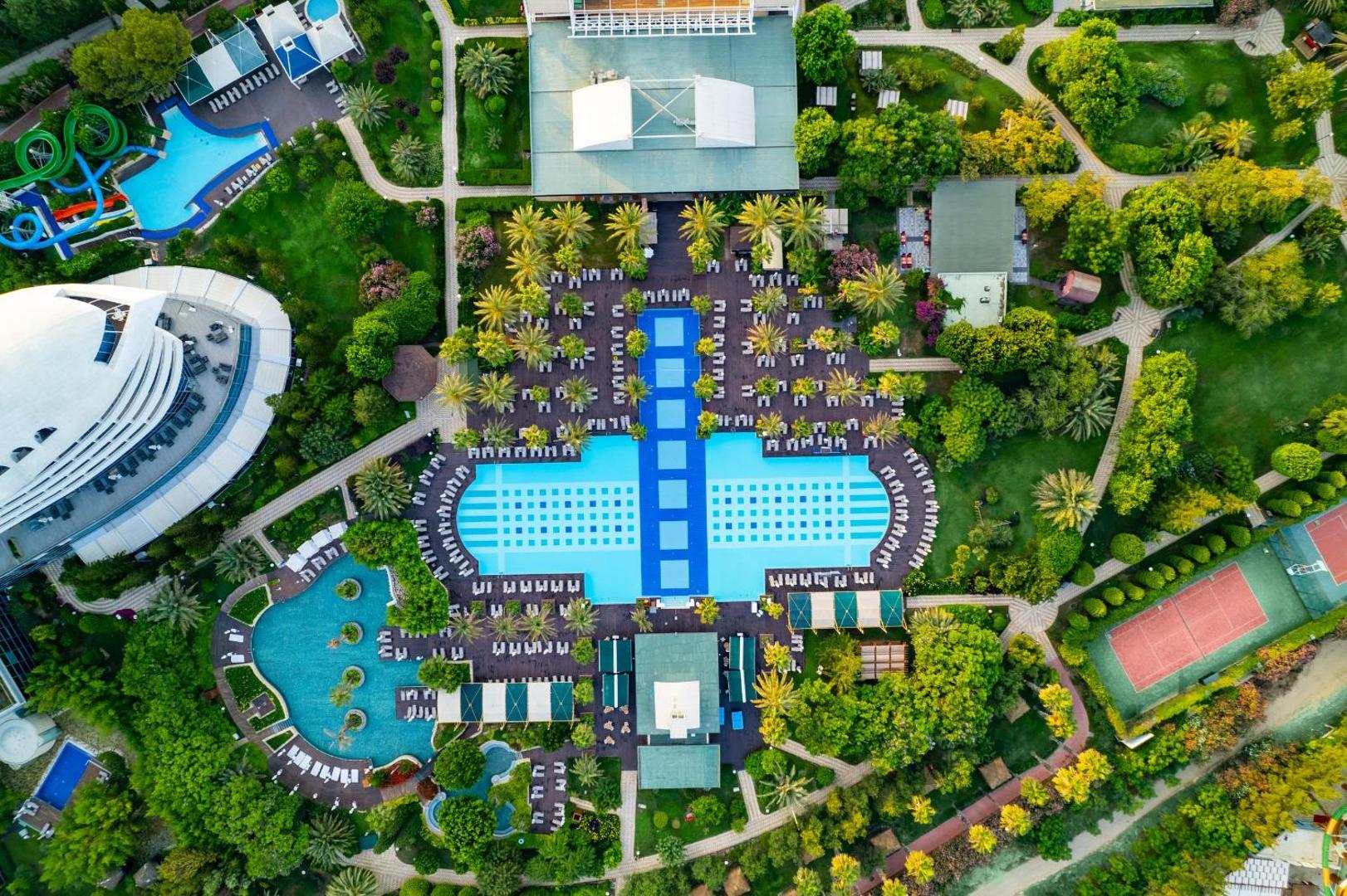 Concorde De Luxe Resort skats no putna lidojuma uz galveno baseinu kompleksu, dārziem un tenisa kortu Antaljas piekrastē, Turcijā.