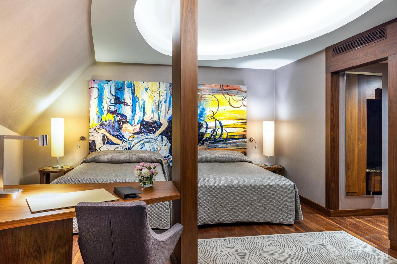 Concorde De Luxe Resort numurs ar divām gultām un mākslas darbiem pie sienām Antaljā, Turcijā — darba galds un mājīgs apgaismojums