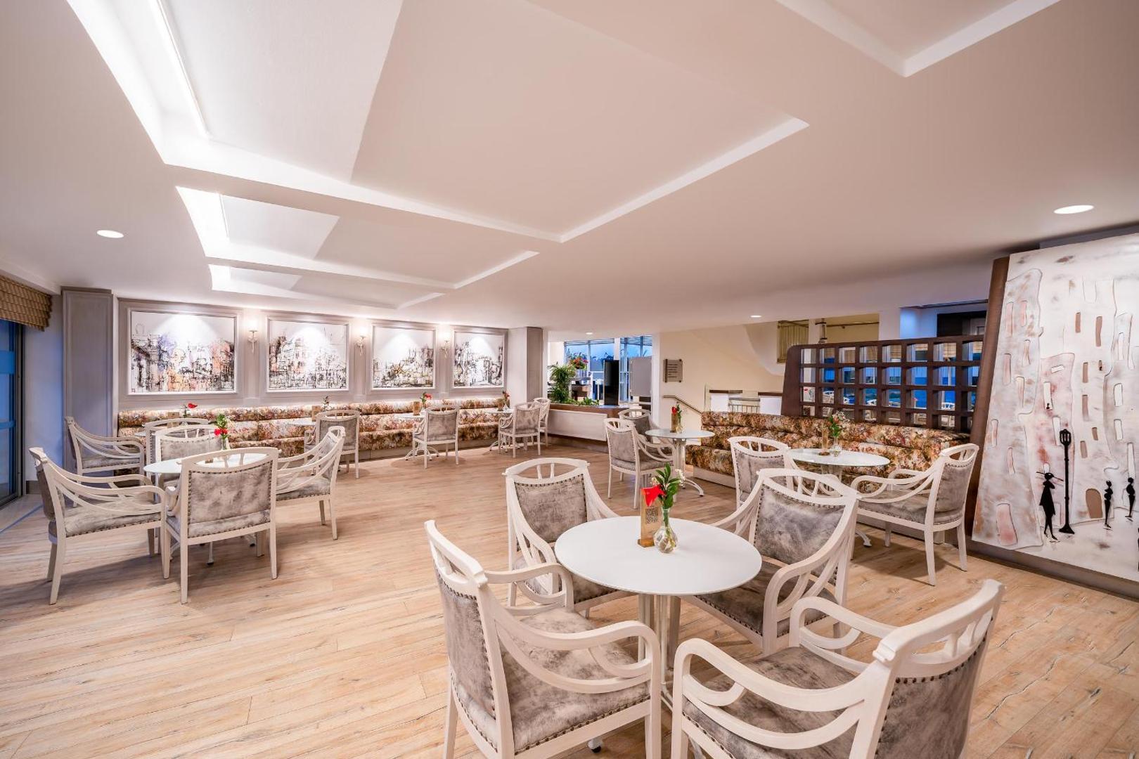 Concorde De Luxe Resort viesnīcas atpūtas telpa ar klasiskām mēbelēm, gleznām pie sienām un gaišu koka grīdu Antaljas reģionā