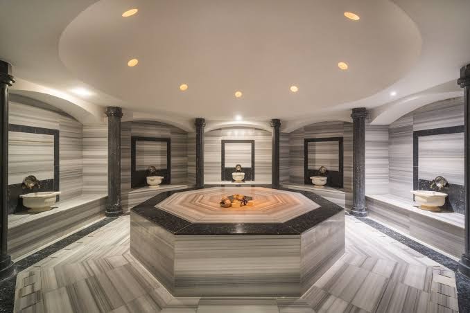 Concorde De Luxe Resort spa centra tradicionālais turku hamams ar marmora apdari, centrālo akmens platformu un dekoratīvām kolonnām