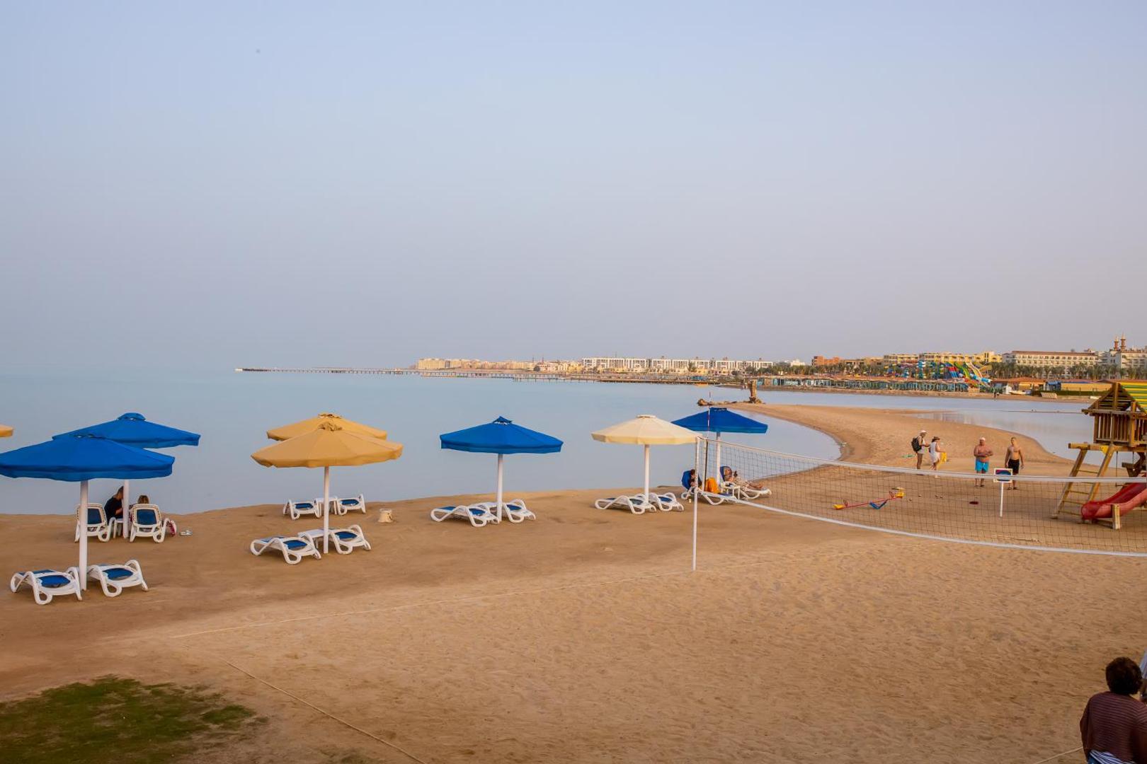 Plašs skats uz Bellagio Beach Resort & Spa pludmali ar volejbola tīklu un bērnu rotaļu laukumu Hurgadas piekrastē