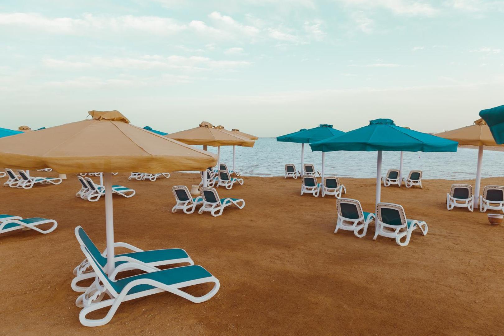 Bellagio Beach Resort & Spa privātā smilšu pludmale ar saulessargiem un sauļošanās krēsliem pie Sarkanās jūras Hurgadā