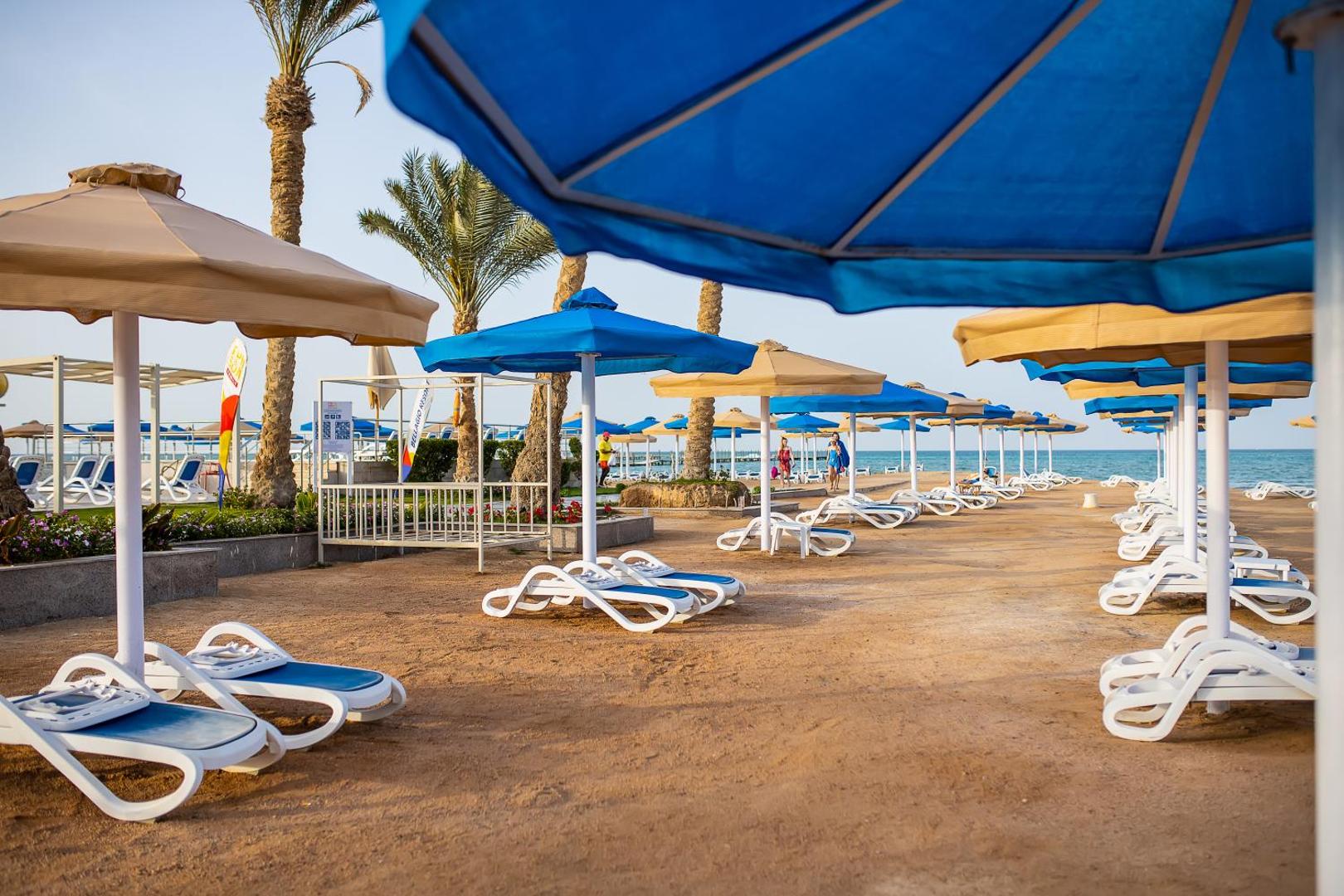 Bellagio Beach Resort & Spa privātā pludmale Hurgadā ar saulessargiem un zviļņiem Sarkanās jūras krastā — plaša smilšu zona atpūtai