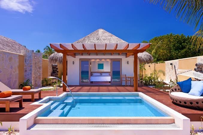 Sheraton Maldives Full Moon Resort & Spa bungalo ar privātu baseinu, koka terasi un skatu uz okeānu saulainā dienā