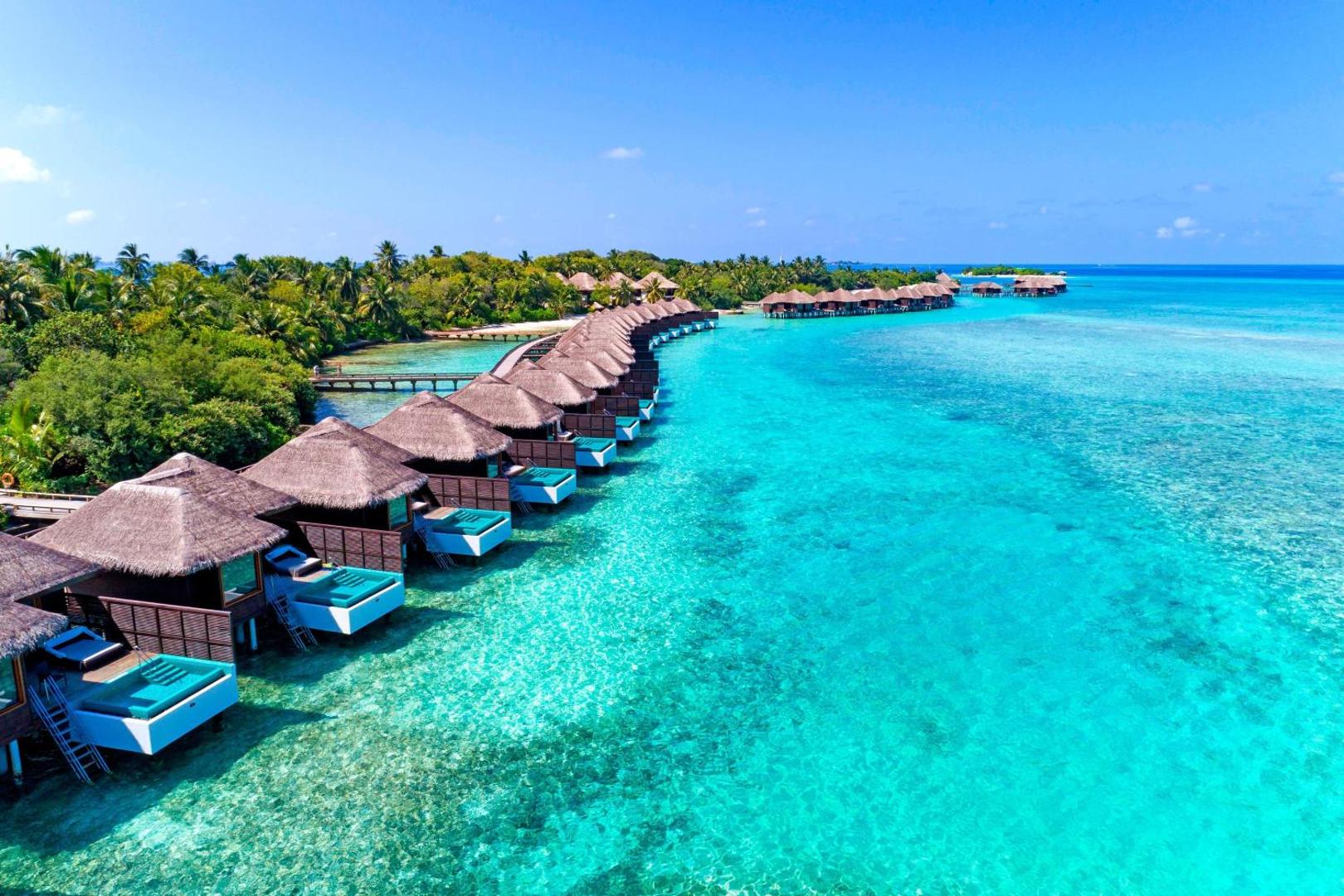 Sheraton Maldives Full Moon Resort & Spa ūdens bungalo rinda virs lagūnas ar privātiem baseiniem un terasēm Maldīvijā