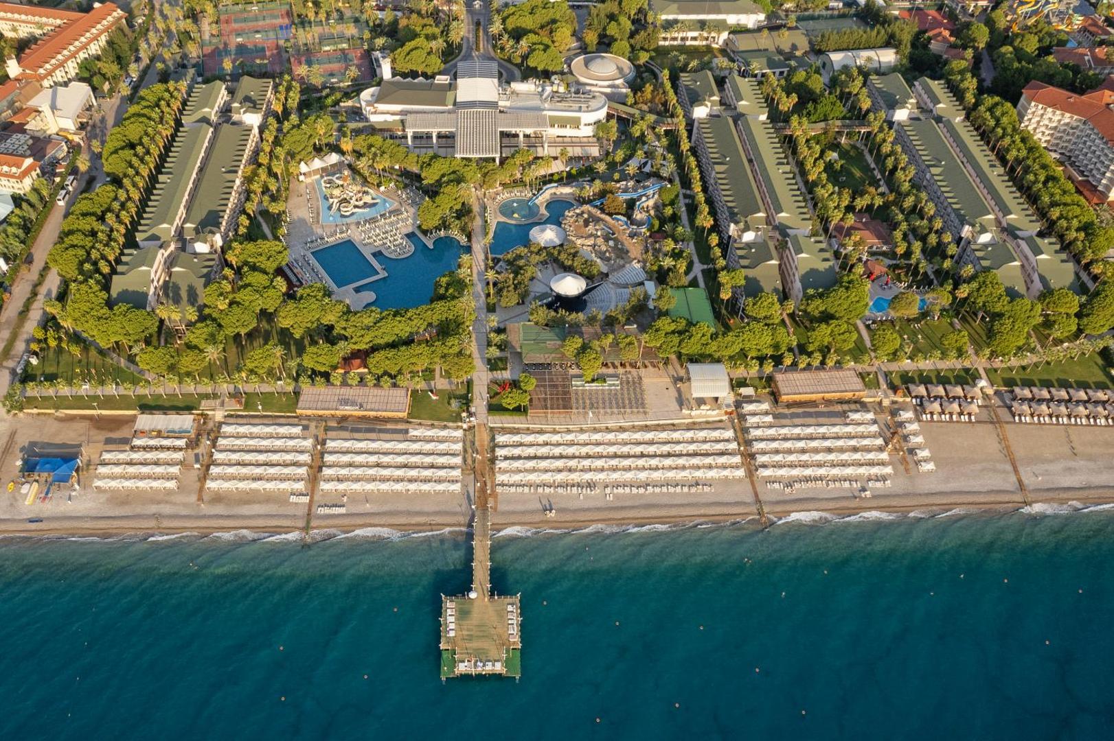 Dobedan World Palace skats no augšas uz privāto pludmali, piestātni un baseinu kompleksu Turcijā — plaša sauļošanās zona pie jūras