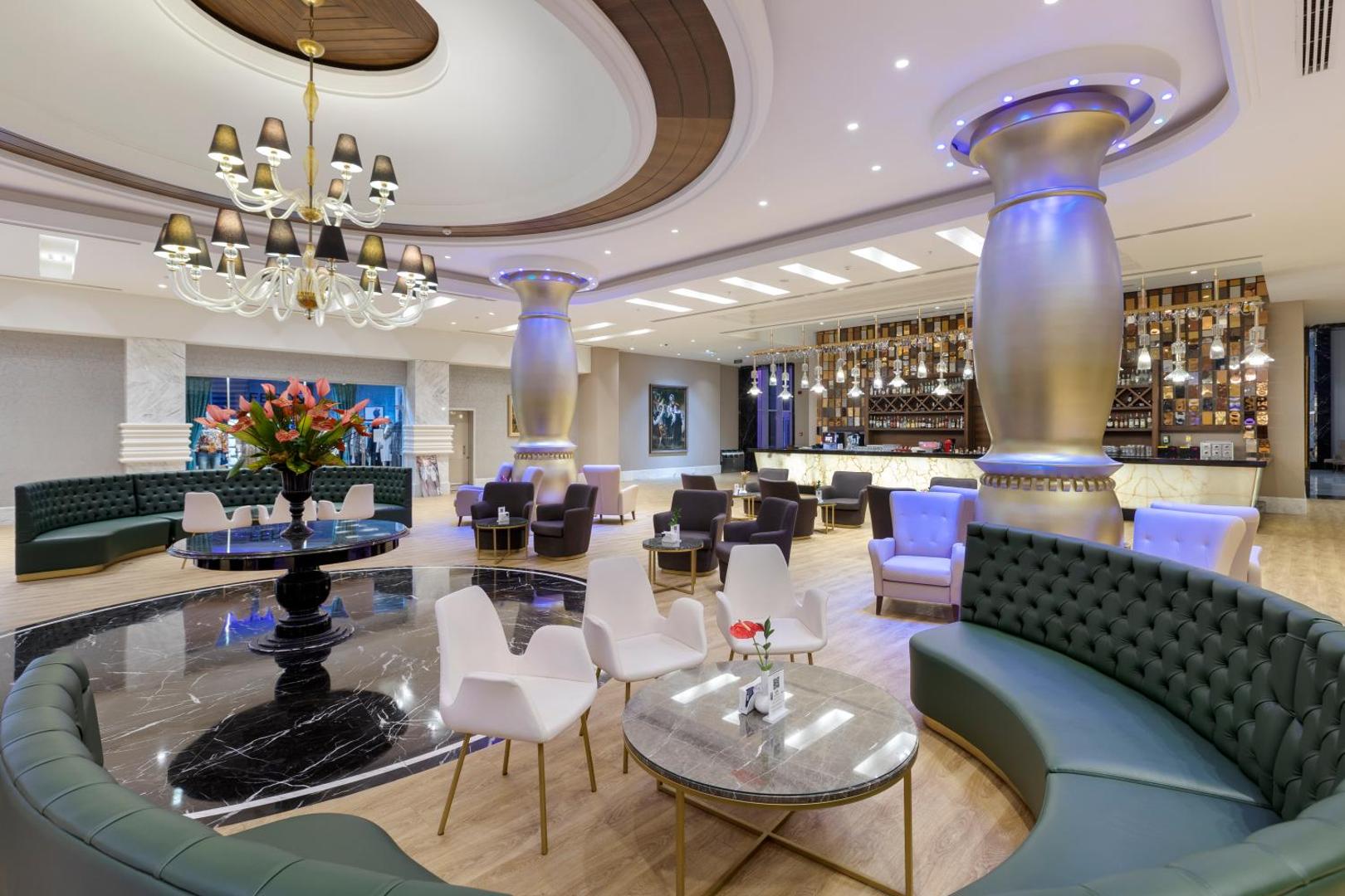 Dobedan World Palace greznais lobby bārs ar mīkstajiem dīvāniem, augstām kolonnām un modernu apgaismojumu Antaljas piekrastē