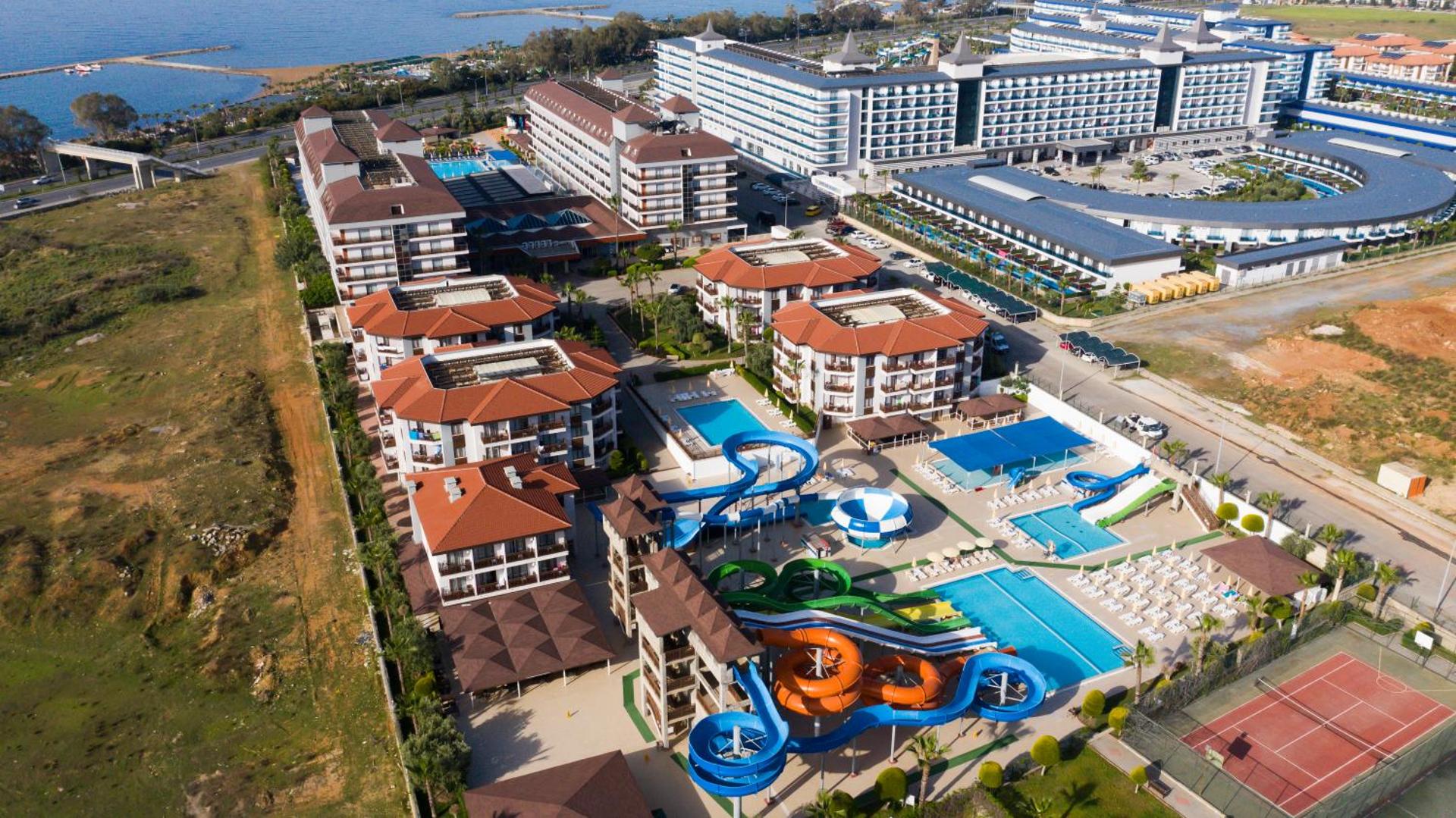 Eftalia Splash Resort Alanjā no putna lidojuma — plašs akvaparks ar krāsainiem slidkalniņiem, vairāki baseini un viesnīcas korpusi pie jūras
