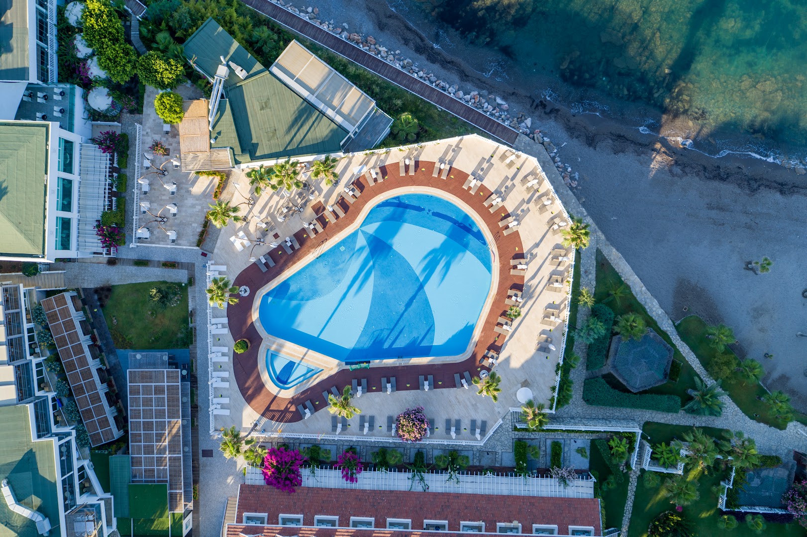 Flora Garden Beach viesnīcas teritorijas skats no putna lidojuma — galvenais baseins, dārzi un tieša pieeja smilšu pludmalei