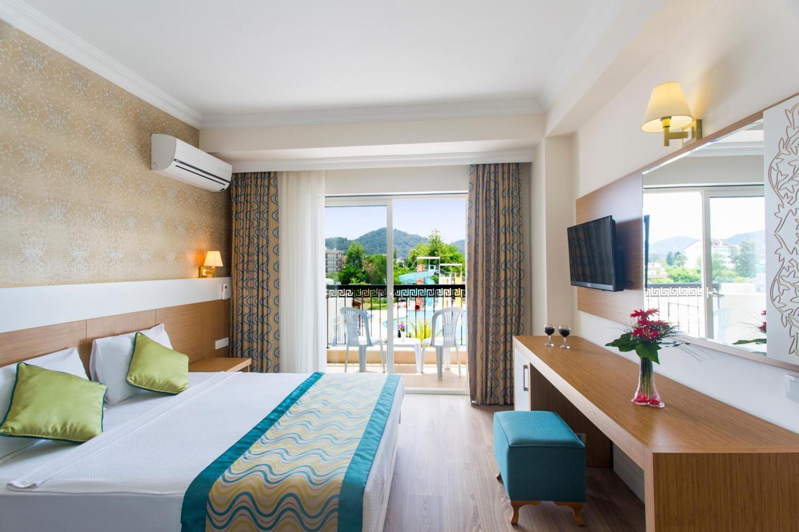 Kemer Dream Hotel gaišs divvietīgs numurs ar balkonu, skatu uz kalniem un akvaparku Kemeras reģionā, Turcijā