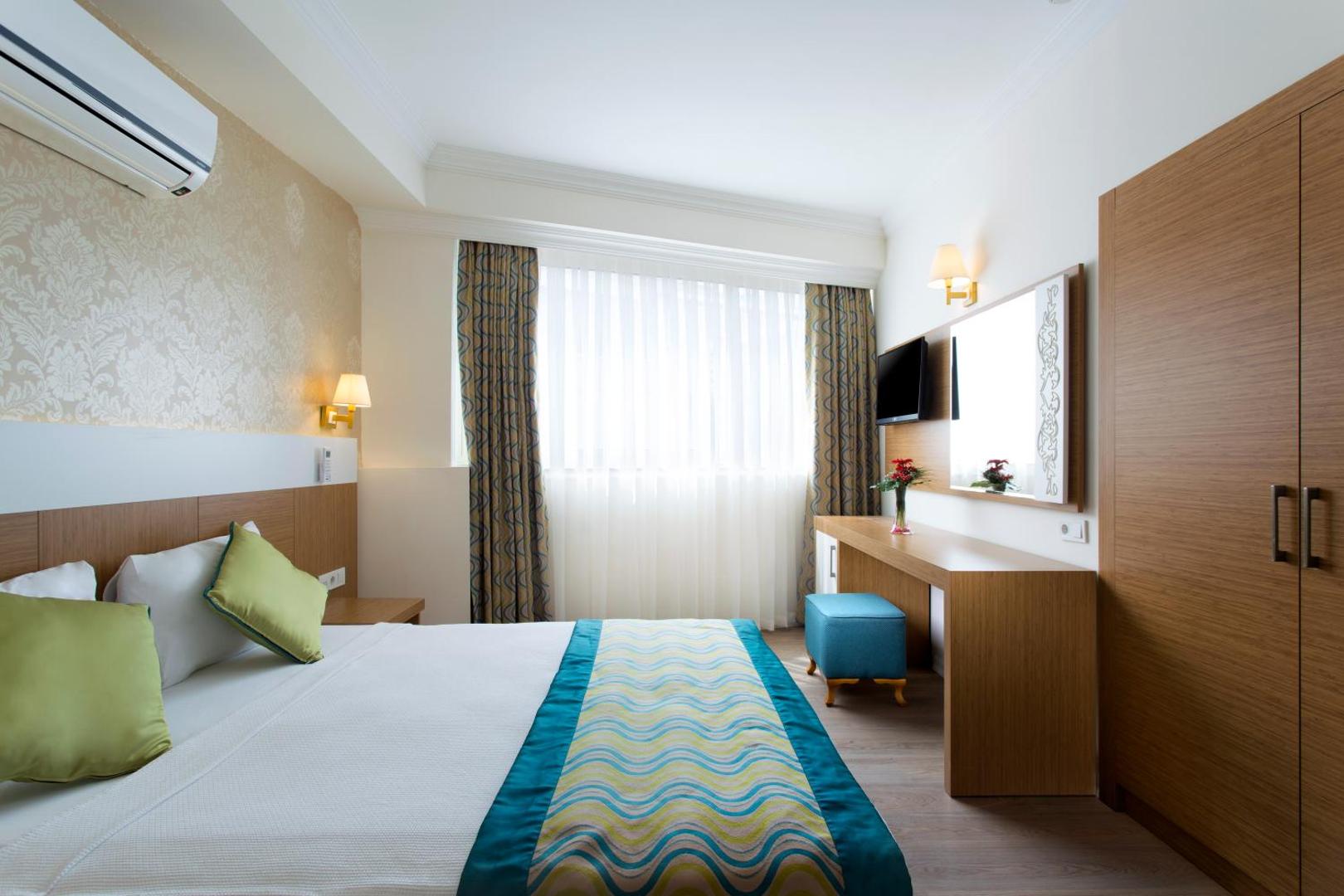 Kemer Dream Hotel divvietīgs numurs ar lielu logu, koka mēbelēm un ziliem akcentiem interjerā