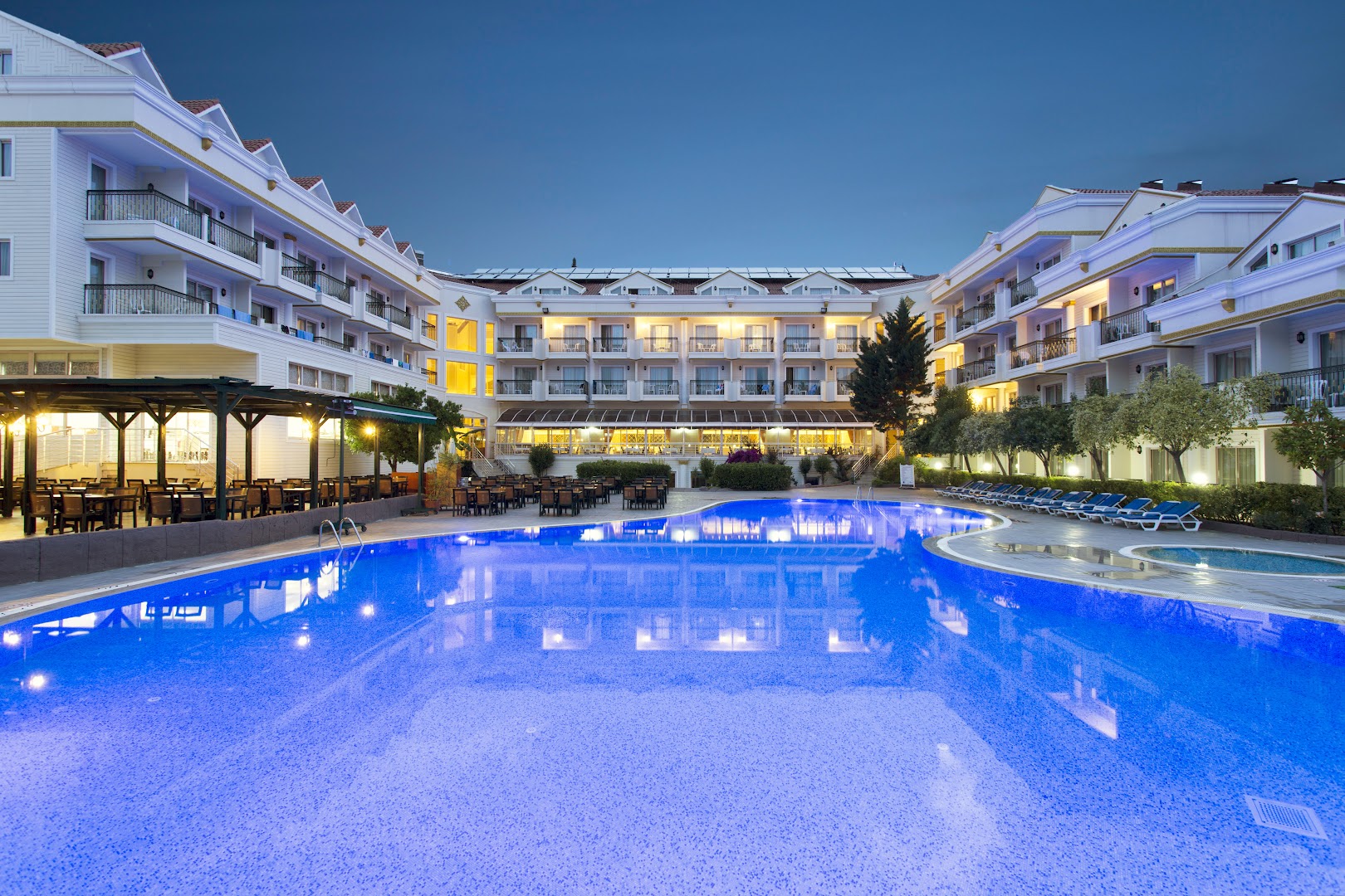 Kemer Dream Hotel izgaismotais baseins un restorāna āra terase vakara stundās Kemeras kūrortā