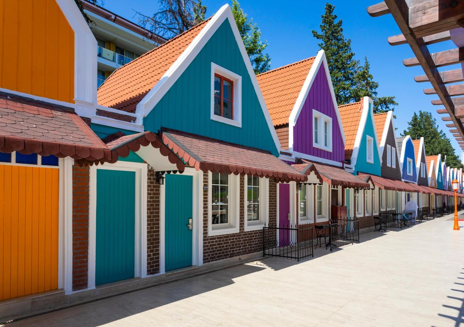 Krāsaini holandiešu stila namiņi Orange County Kemer teritorijā — spilgtas fasādes un tradicionāli jumti pastaigu zonā