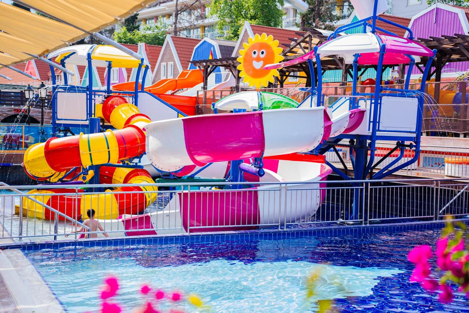 Orange County Kemer akvaparks ar krāsainiem ūdens slidkalniņiem un bērnu baseinu Kemeras kūrortā — saulaina atpūtas zona ģimenēm