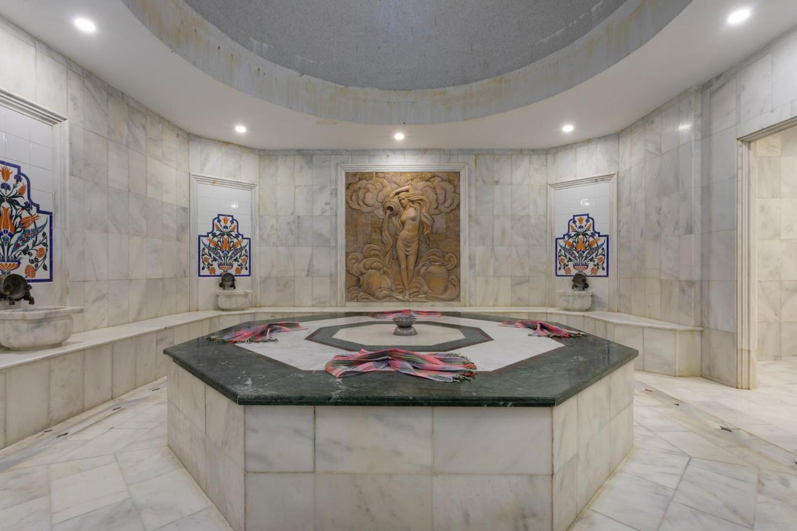 Orange County Kemer spa centra tradicionālais turku hamams ar marmora apdari, centrālo akmens platformu un dekoratīviem sienas reljefiem
