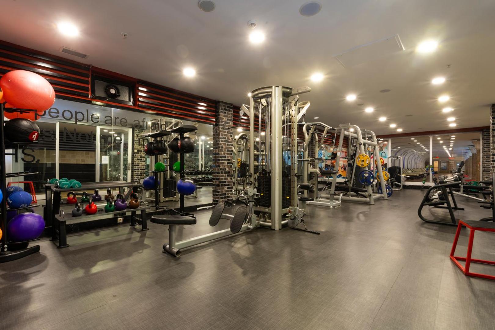 Orange County Kemer modernā fitnesa zāle ar spēka trenažieriem, svariem un vingrošanas bumbām — plaša telpa aktīvam treniņam