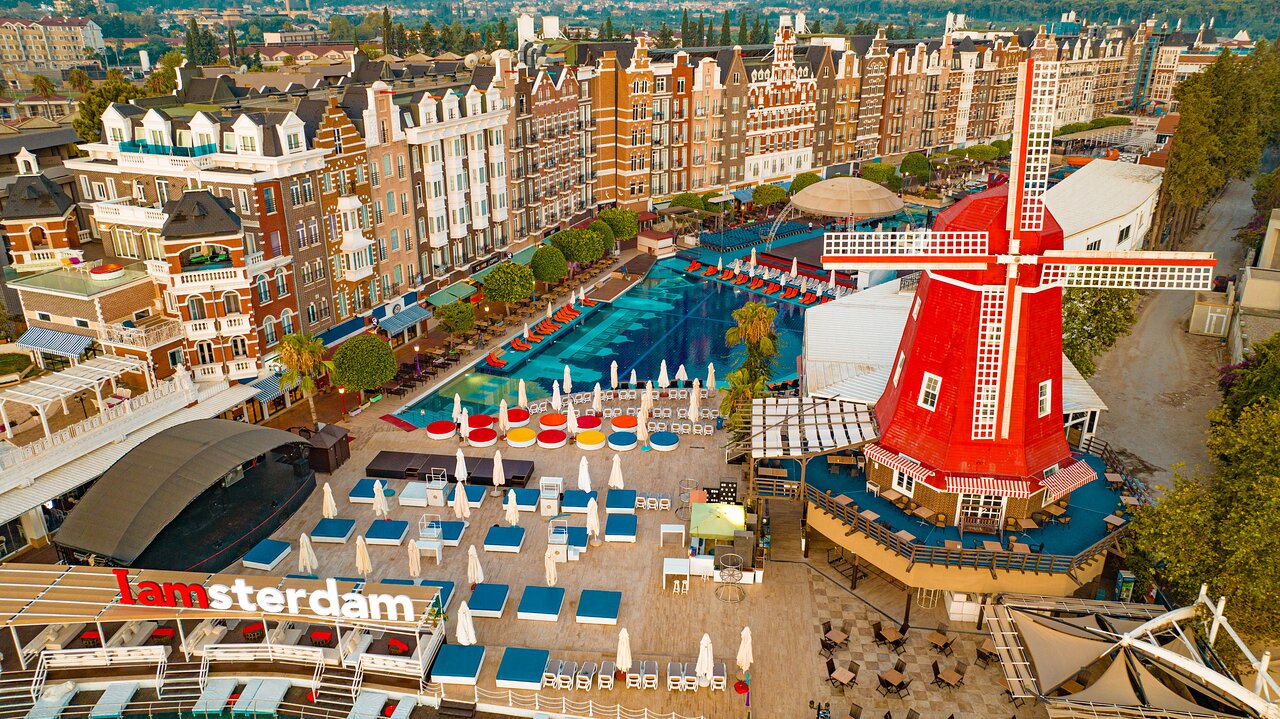Orange County Kemer viesnīcas teritorijas skats no augšas — Amsterdamas arhitektūra, liels baseins, vējdzirnavas un atpūtas zonas Kemerā