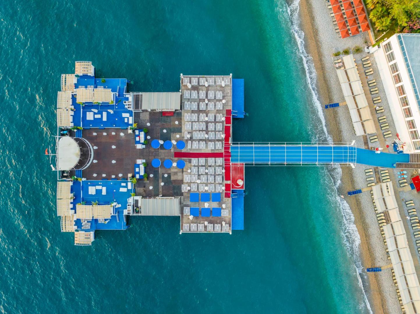 Orange County Kemer privātā piestātne un sauļošanās platforma jūrā — skats no augšas uz zilo Vidusjūras ūdeni un pludmali