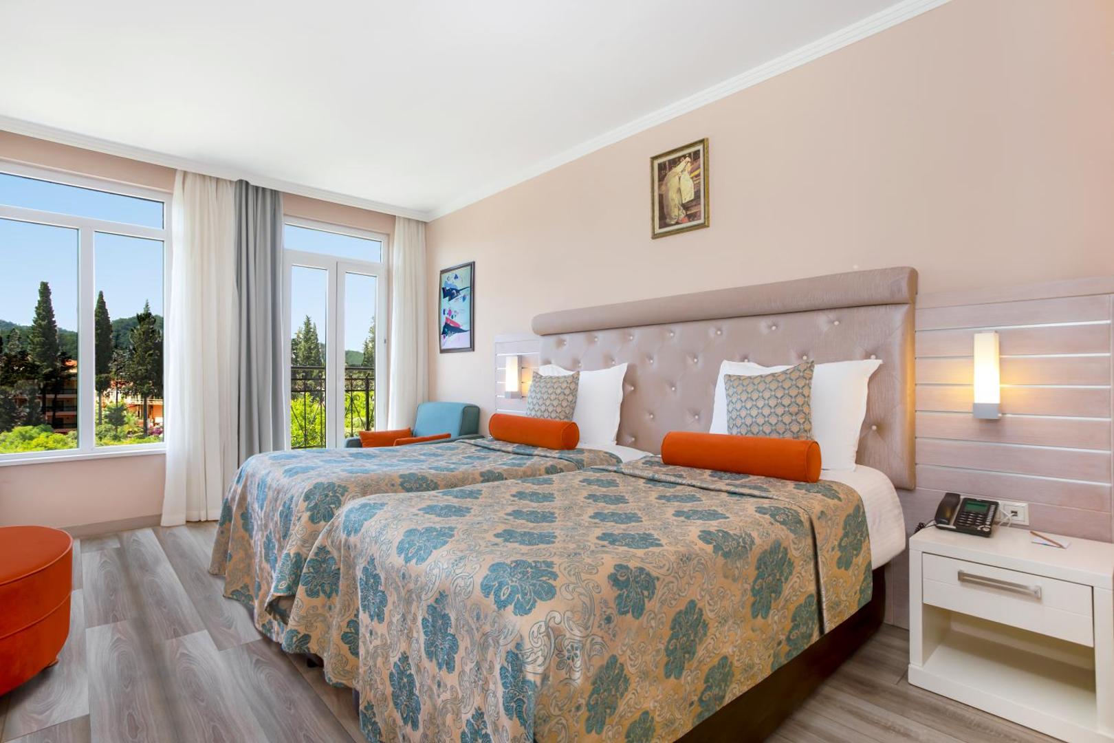 Orange County Kemer gaišs standarta numurs ar divām gultām, lielu logu un skatu uz zaļo zonu Kemeras kūrortā