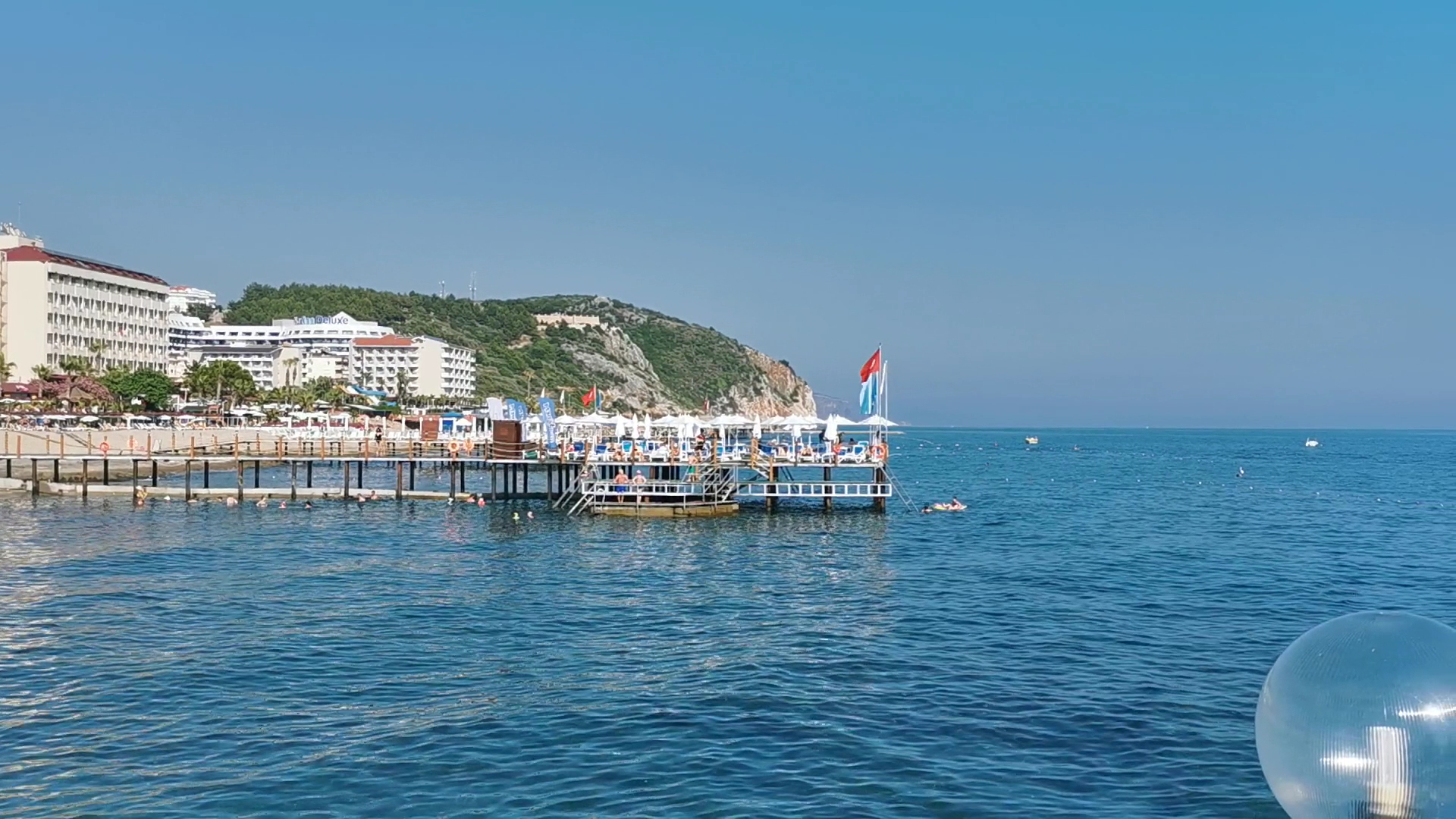 Quattro Beach Spa & Resort skats uz viesnīcas ēku un koka piestātni Vidusjūras piekrastē, Konakli reģionā, Turcijā.