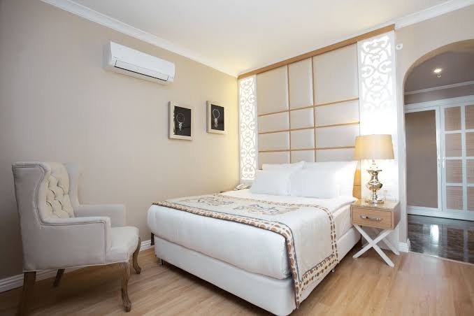 Quattro Beach Spa & Resort gaišs divvietīgs numurs ar mīksto krēslu, gaisa kondicionieri un elegantu sienas paneli Alanjā