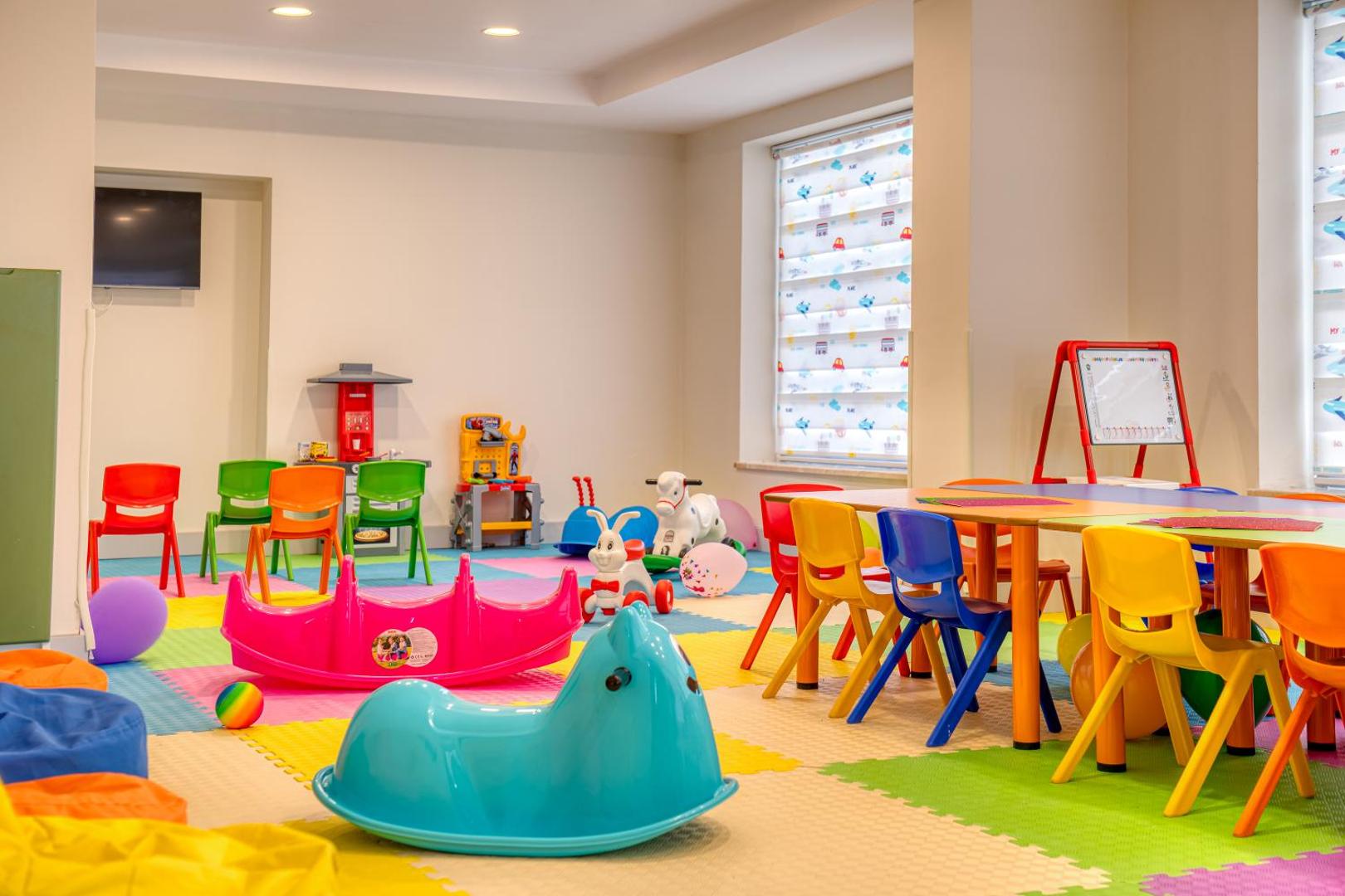 Sealife Kemer Resort Hotel iekštelpu bērnu klubs ar krāsainām mēbelēm, rotaļlietām un mīkstu grīdas segumu