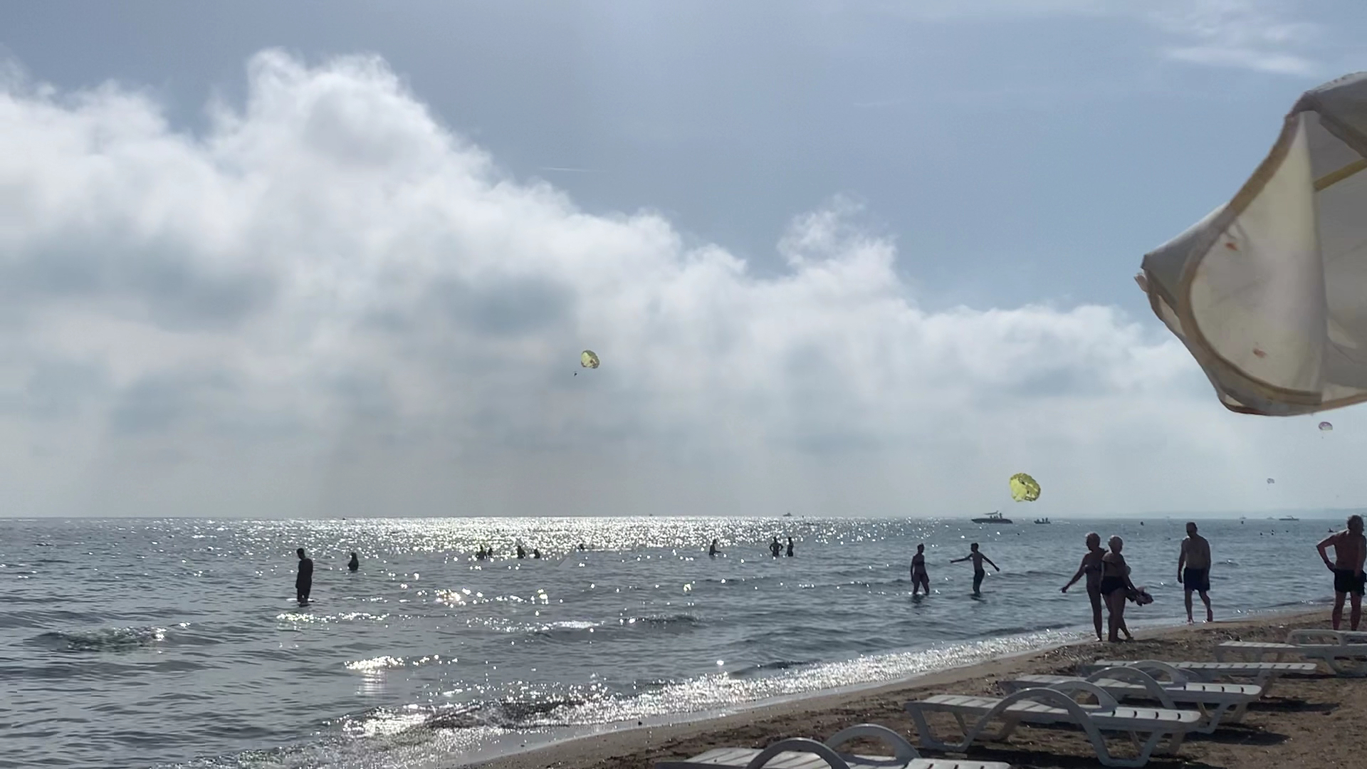 TUI BLUE Barut Andiz viesnīcas privātā pludmale ar saulessargiem, sauļošanās krēsliem un cilvēkiem, kas peldas Vidusjūrā