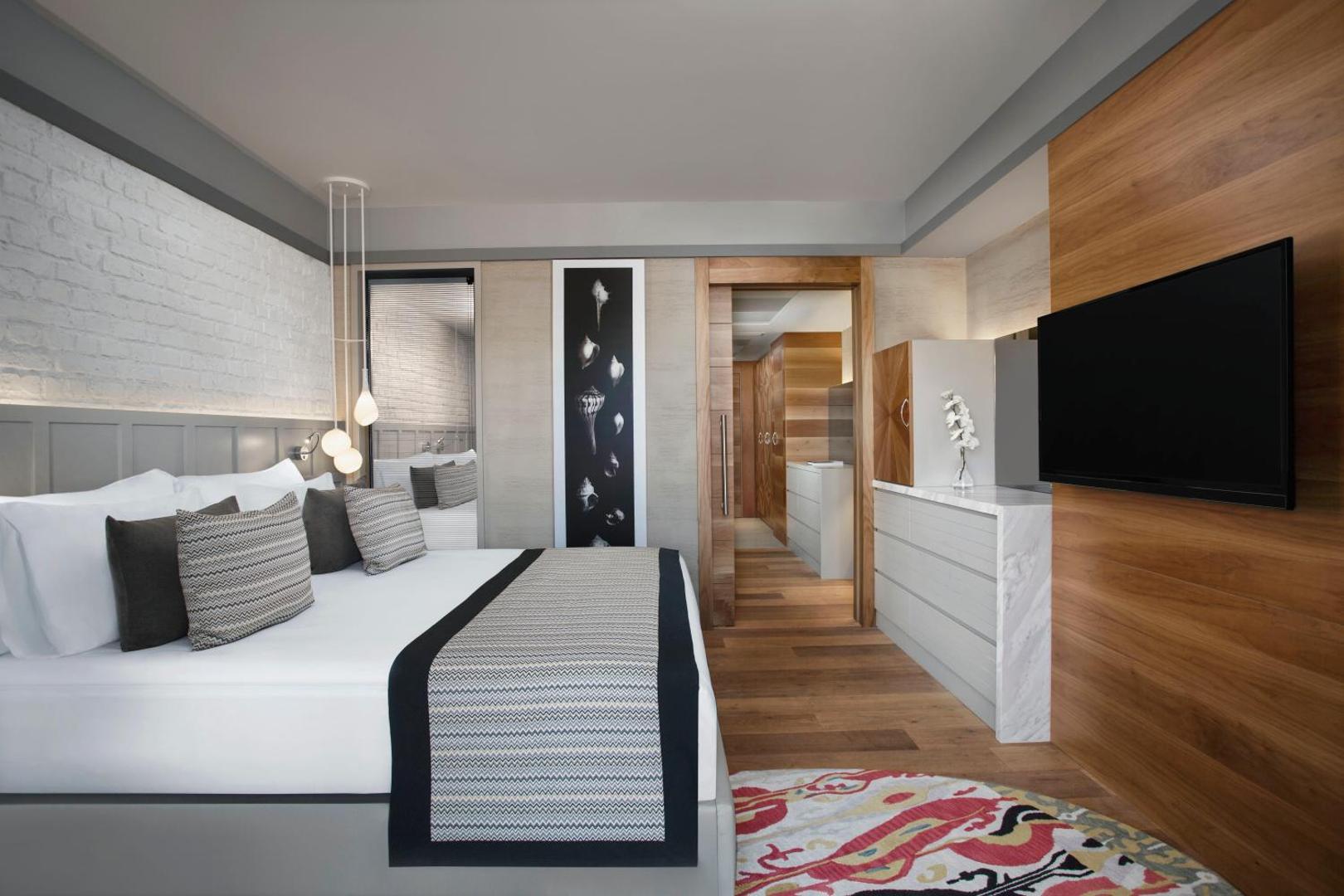 Acanthus & Cennet Barut Collection viesnīcas numura interjers ar divguļamo gultu, koka apdari un modernu dizainu Turcijas piekrastē