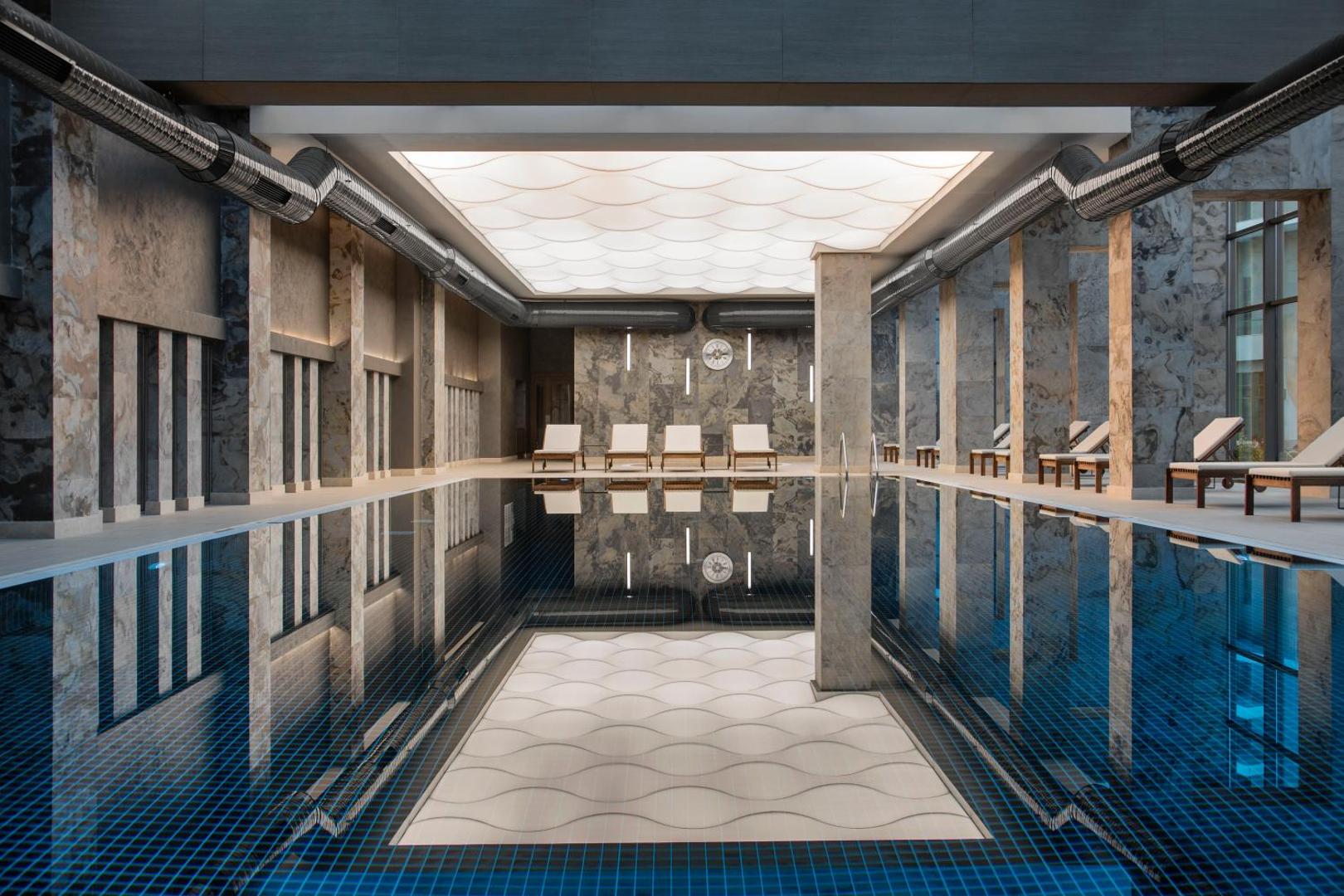 Acanthus & Cennet Barut Collection moderns iekštelpu spa baseins ar marmora apdari un atpūtas krēsliem