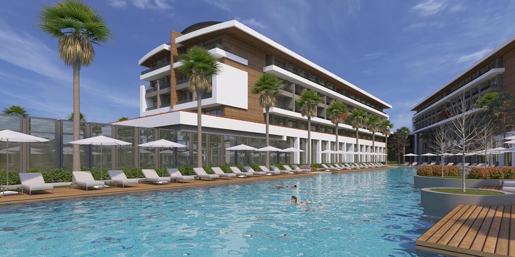 Acanthus & Cennet Barut Collection garais āra peldbaseins ar sauļošanās krēsliem, saulessargiem un palmām pie viesnīcas korpusa