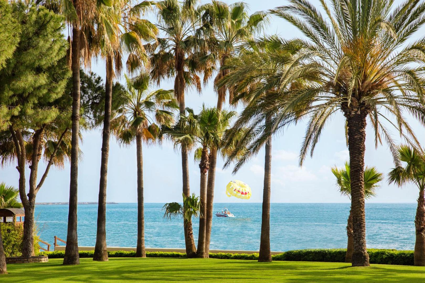 Skats no Acanthus & Cennet Barut Collection dārza uz Vidusjūru ar izklaides laivu un izpletni Sidē, Turcijā