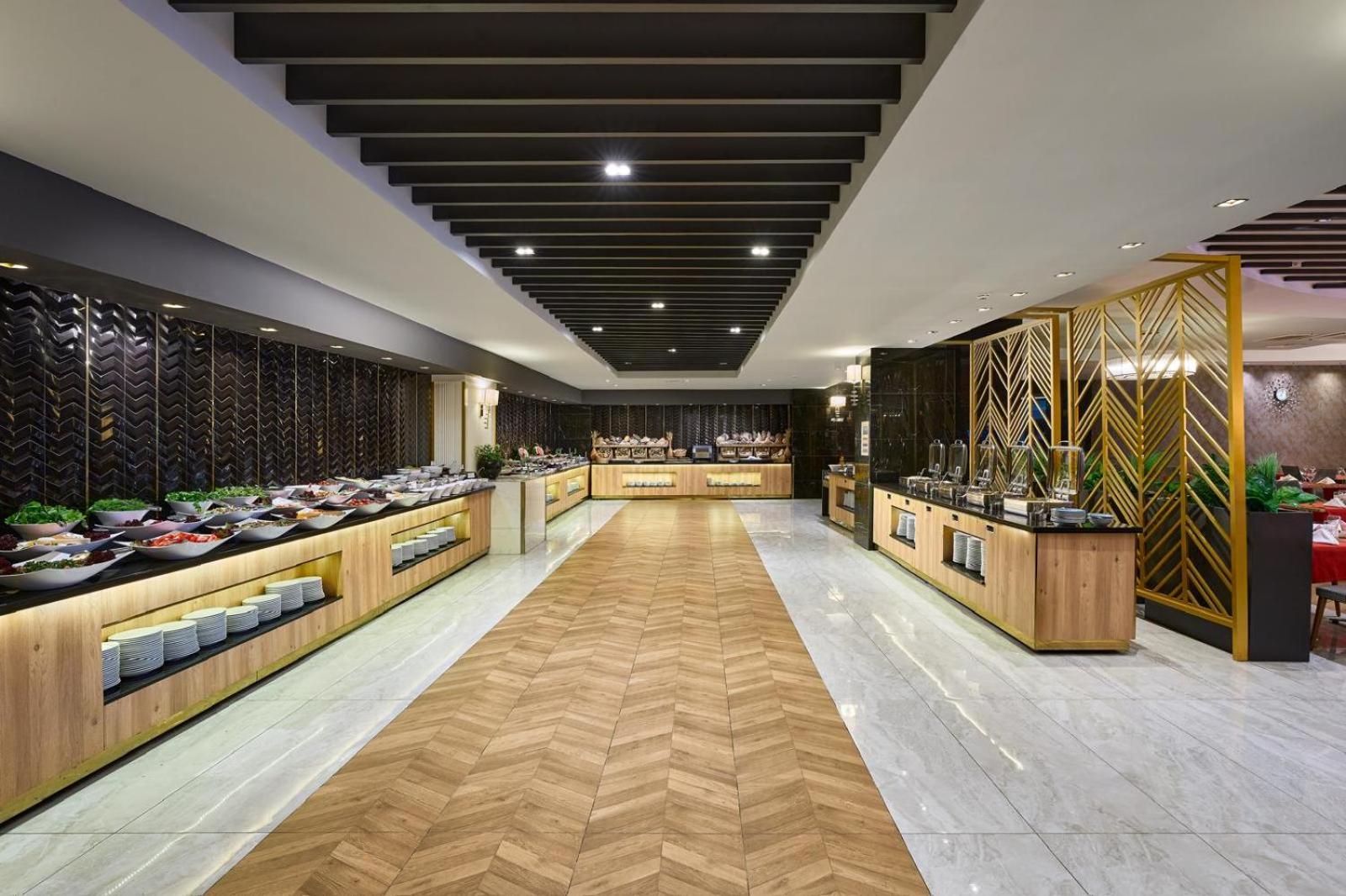 Annabella Diamond Hotel bufetes zona ar plašu uzkodu un salātu izvēli uz koka apdares galdiem modernā interjerā