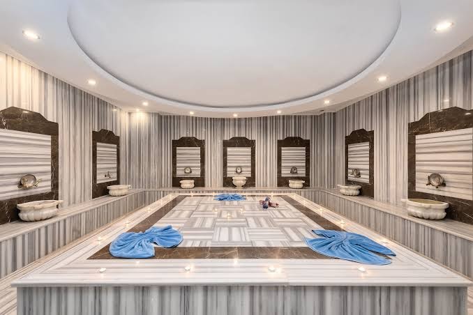 Gaišs marmora hamams Annabella Diamond Hotel kūrortā Alanjā — tradicionālas mazgāšanās vietas un apsildāma centrālā platforma atpūtai