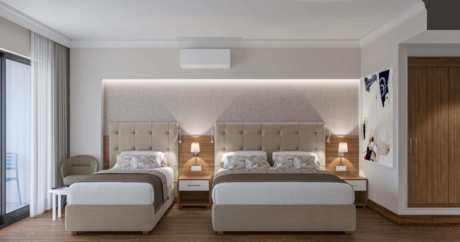 Annabella Diamond Hotel moderns numurs ar divām gultām, gaišu interjeru un koka grīdu Alānijā, Turcijā — mājīga atpūtas zona pie loga