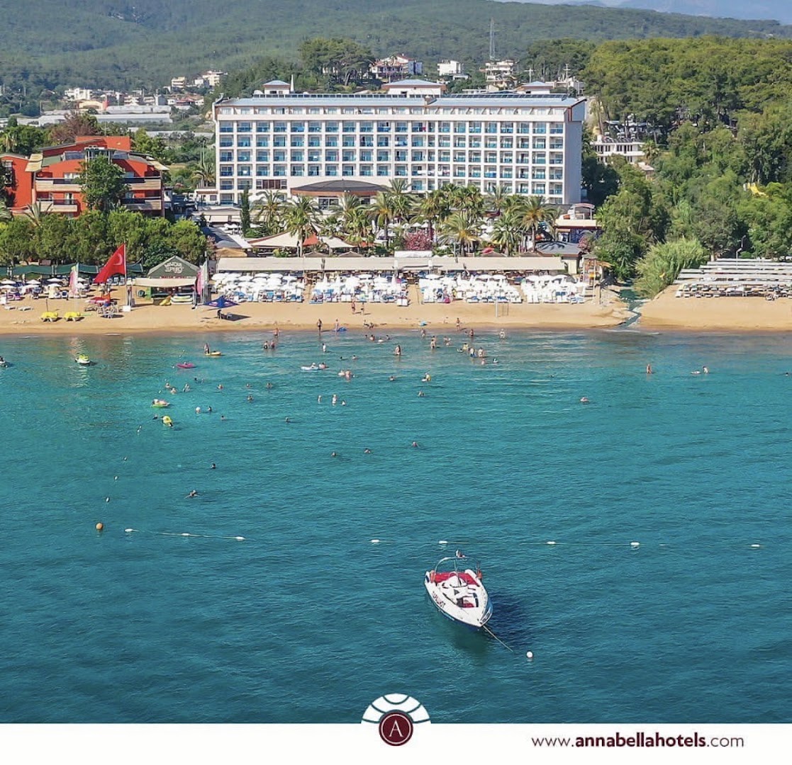 Annabella Diamond Hotel privātā smilšu pludmale ar saulessargiem un gultām pie dzidri zilā Vidusjūras ūdens
