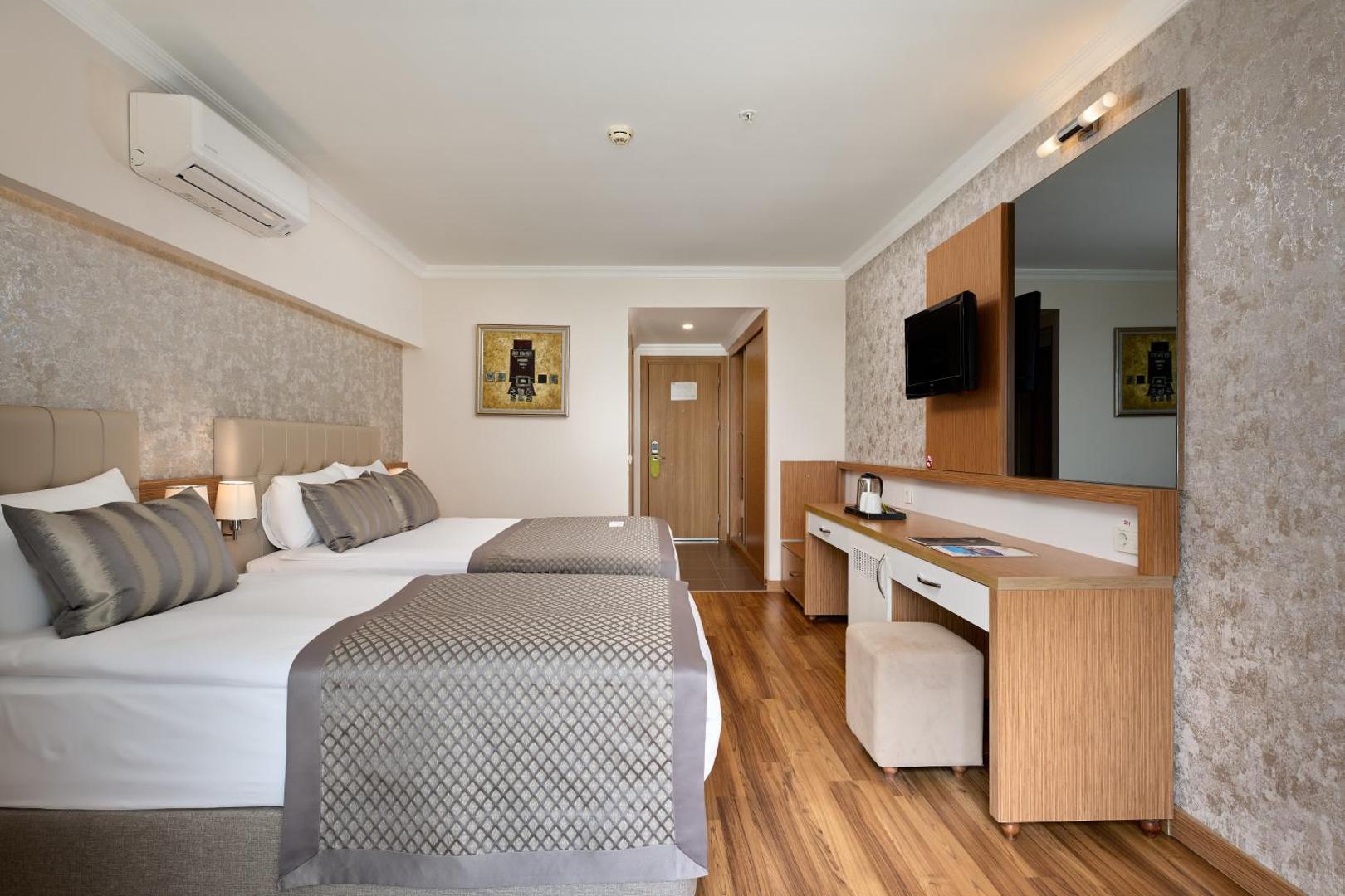Annabella Diamond Hotel plašs numurs ar divām gultām, rakstāmgaldu, televizoru un gaisa kondicionieri — gaišs interjers ar koka elementiem