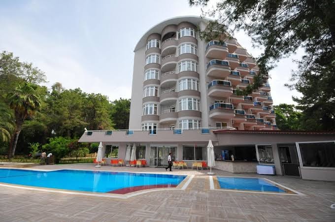 Annabella Diamond Hotel papildu korpuss ar pusapaļiem balkoniem un āra baseinu, ko ieskauj priežu mežs