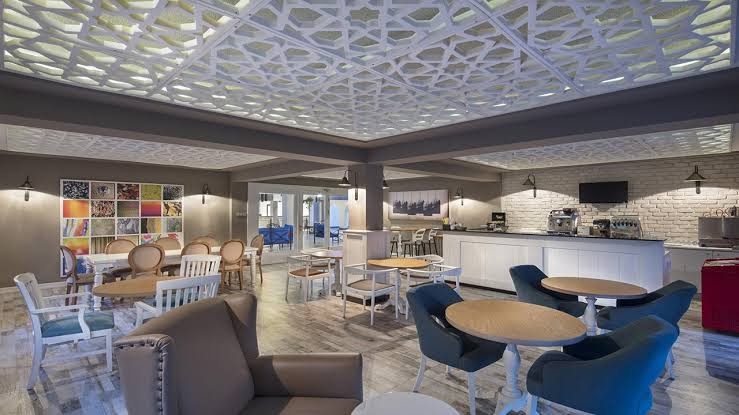 Club Marco Polo iekštelpu bārs un atpūtas zona ar modernu dizainu, rakstainiem griestiem un ērtiem atpūtas krēsliem