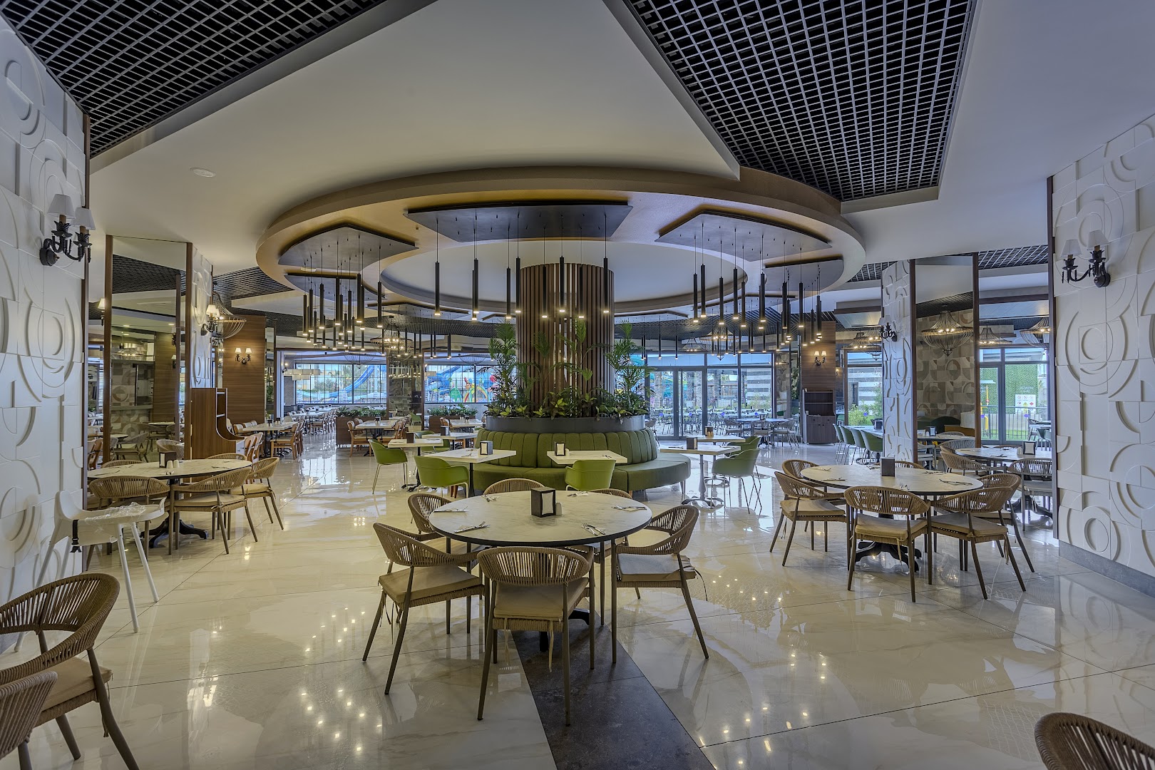 Eftalia Blue Hotel plašais galvenais restorāns ar apaļiem galdiem, modernu apgaismojumu un gaišu interjeru Alanjā