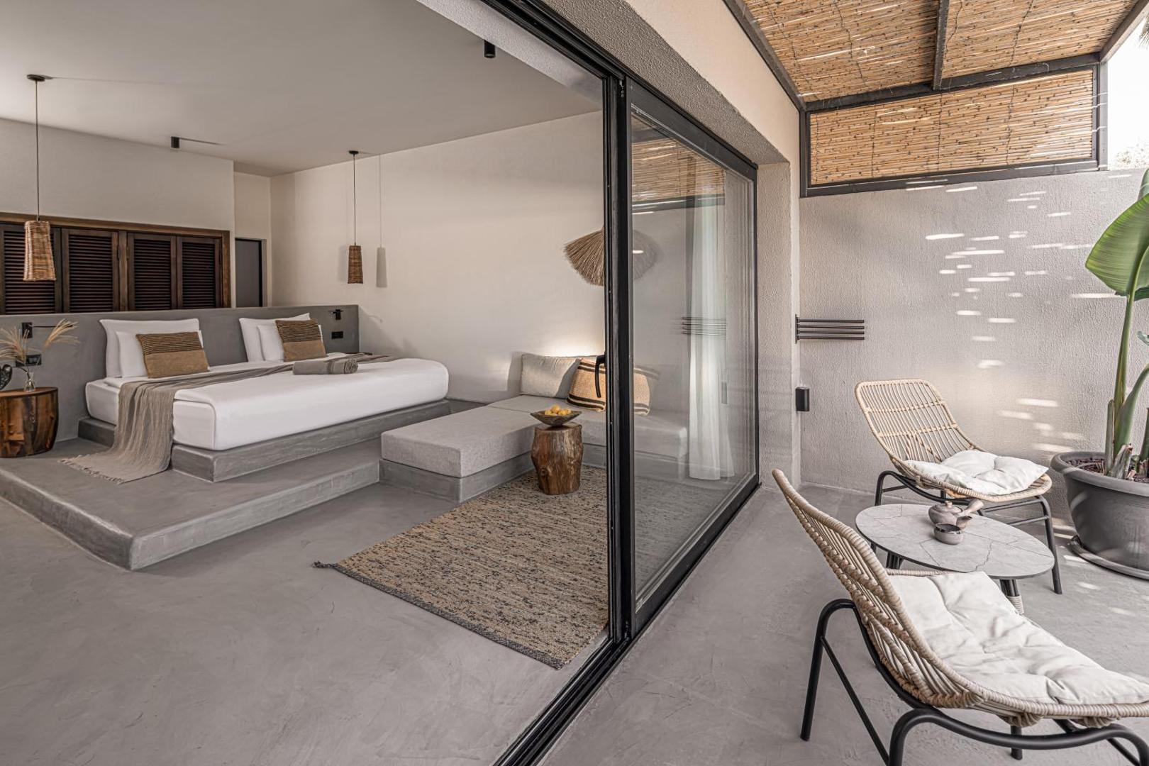 Balmy Beach Resort Kemer moderns numurs ar privātu terasi, pītiem krēsliem un minimālisma stila interjeru Kemeras piekrastē Turcijā
