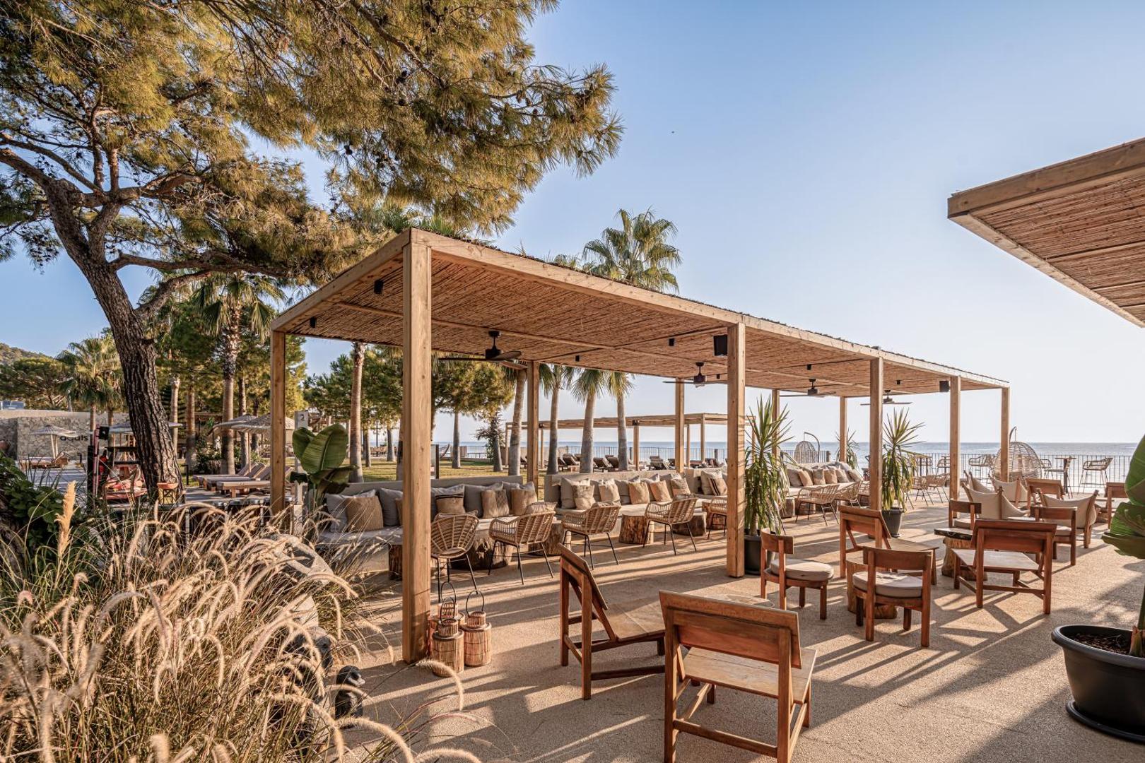 Āra terase ar koka mēbelēm un nojumi Balmy Beach Resort Kemer viesnīcā pie jūras
