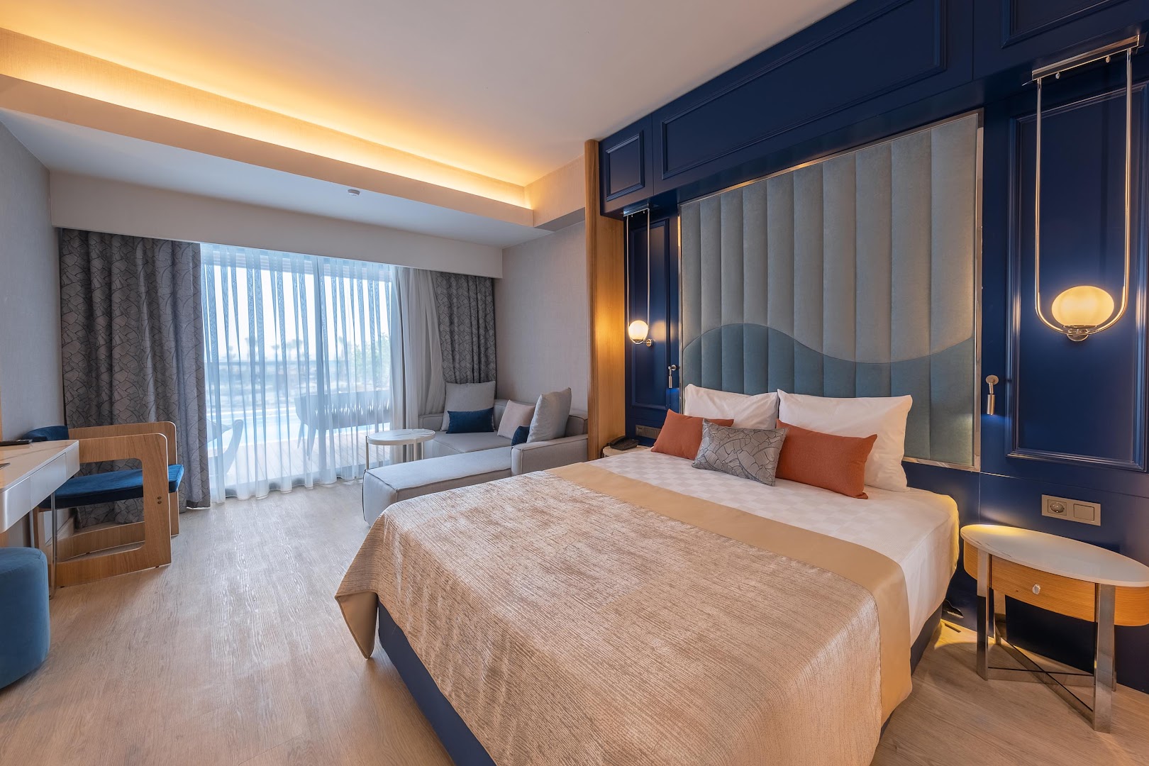 Lago Hotel luksusa numurs ar dizaina sienas paneli zilā krāsā, atpūtas dīvānu un skatu uz baseinu caur logu