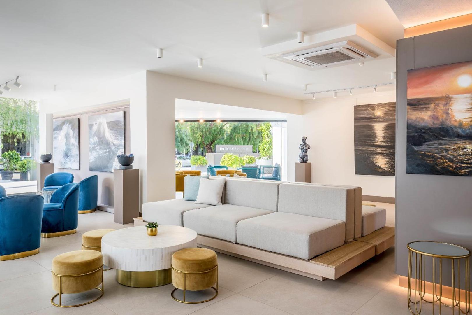 Occidental Puerto Banus viesnīcas lobby zona ar moderniem dīvāniem, krāsainiem krēsliem un mākslas darbiem pie sienām Marbeljā, Spānijā