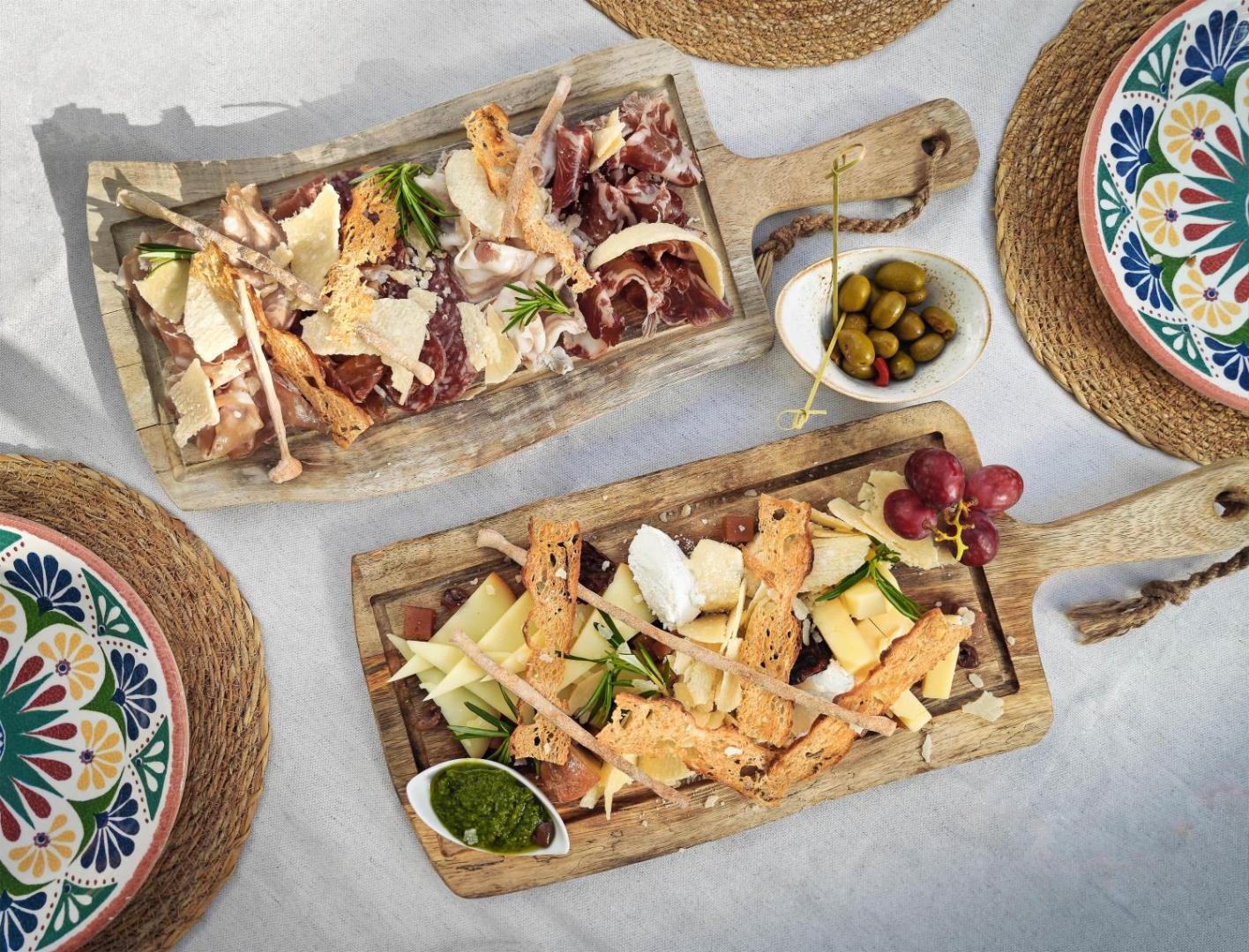 Tradicionālas spāņu uzkodas uz koka dēlīšiem Occidental Puerto Banus restorānā — siers, vītināta gaļa un olīvas